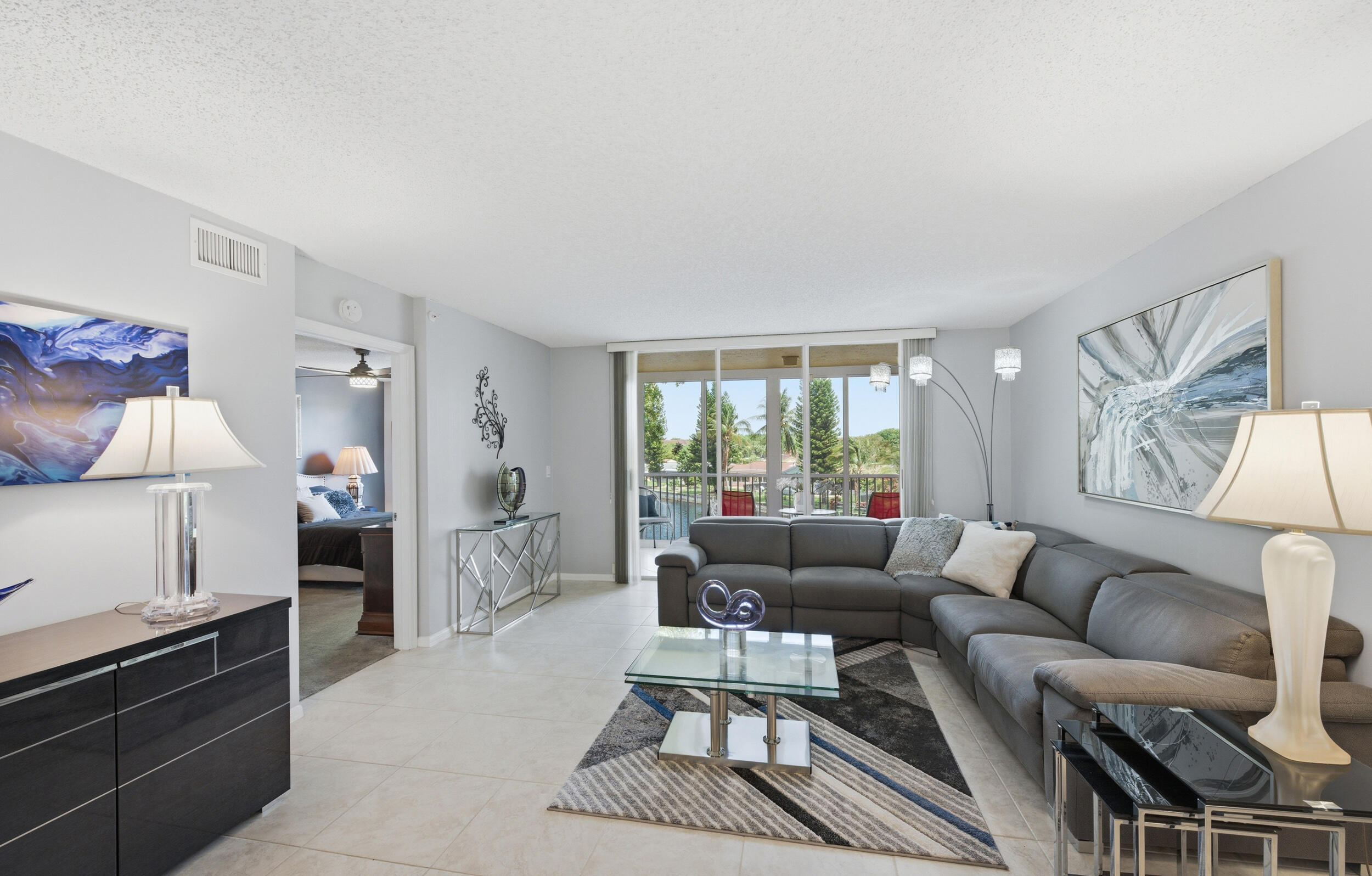 Welcome to Weldon at Kings Point — one of Tamarac's most sought-after 55+ communities. This beautifully updated 2-bedroom, 2-bath residence offers one of the larger floor plans in the community with 1,469 sq ft of spacious, light-filled living. Located on the 3rd floor just steps from the elevator, this move-in ready condo features a renovated kitchen with sleek cabinetry, granite countertops, stainless steel appliances, and designer finishes. The expansive living and dining areas flow seamlessly to an enclosed patio with sliders and screens overlooking tranquil lake views — the perfect space to relax year-round. The oversized primary suite offers generous closet space and a private bath, while the versatile second bedroom is ideal for guests, hobbies, or a home office. Enjoy resort-style living with incredible amenities and outstanding value. Association fees include cable, internet, water, sewer, trash, security,  clubhouse amenities, and so much more. This is an exceptional opportunity to enjoy low-maintenance South Florida living in a gated, amenity-rich community close to shopping, dining, and major roadways.