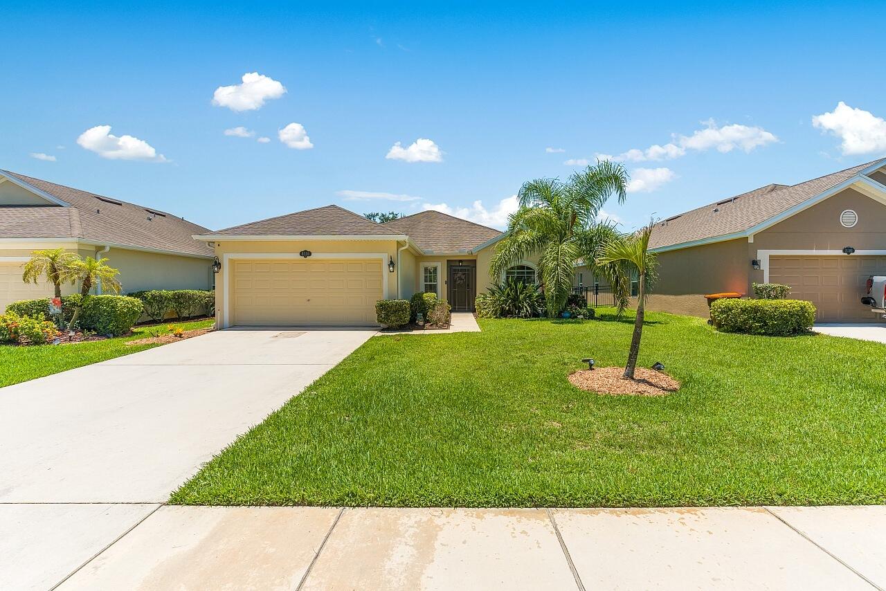 Coastal charm meets easy Florida living in this beautifully updated 2015 CBS home located in the desirable gated Westfield community of Vero Beach. Offering 1,541 sq ft under air, this 3-bedroom, 2-bathroom residence features a sought-after split floor plan, 2-car garage, and peaceful water lake views without the expense or maintenance of direct waterfront ownership.  The heart of the home is the recently renovated kitchen, showcasing oversized shimmer-finish epoxy countertops, generous seating for four, soft-close cabinetry, custom lighting, and an inviting eat-in dining area perfect for everyday living and entertaining. Tile and LVP flooring flows throughout the home and is complemented by updated ceiling fans and coastal-inspired finishes.  A formal dining room provides additional space for gatherings and special occasions. The primary suite features an updated double-sink vanity with quartz countertops and a modern LED anti-fog mirror. Outside, enjoy a professionally landscaped yard featuring attractive garden beds, exterior accent lighting, a black iron fenced backyard for pups or family, irrigation well with new pump, and tranquil water views. Additional highlights include garage cabinetry and an included newer GE Profile washer and dryer. Westfield residents enjoy gated entry, sidewalks, streetlights, lawn and shrub maintenance, county water and sewer, and a convenient location near shopping, dining, medical facilities, I-95, and Vero Beach's beautiful beaches.