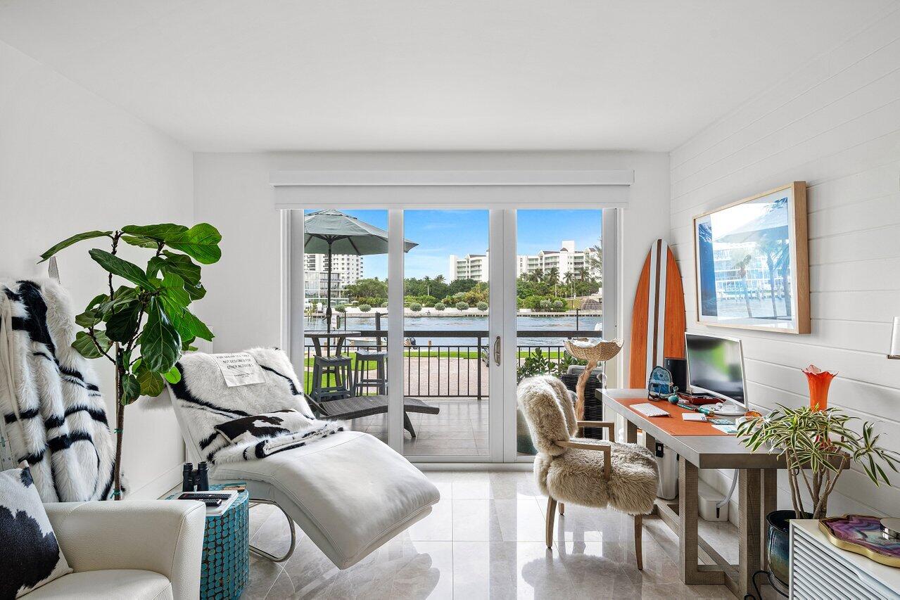 Stunningly renovated 1 BD 1 BA residence in The Carlton, positioned directly on the intracoastal with breathtaking water views, including picturesque vistas of Lake Boca. Perfectly situated just off the Boca Inlet and adjacent to the community dock, this residence offers a front row seat to the area's most coveted waterfront scenery. The slight elevation of this first-floor unit creates the ideal balance of privacy and proximity, allowing you to enjoy the coastal breeze and tranquil sounds of the water from the comfort of your home. Accessible from both the living room and primary bedroom, the expansive balcony serves as an ideal setting for relaxing and taking in the ever-changing waterfront views. Inside, the turnkey interiors showcase a sophisticated luxury coastal aesthetic.  The showstopping kitchen features a striking geode-inspired stone peninsula that overlooks the living area and water views beyond. Rich wood tones paired with crisp white cabinetry create a warm yet refined atmosphere, while the open layout allows for seamless entertaining. The spacious living room is filled with natural light through wide sliding glass doors that frame the intracoastal, Lake Boca, and inlet views. The primary bedroom continues the home's bright and airy feel, complemented by tasteful coastal-inspired accent details and direct balcony access. The beautifully designed bathroom offers a spa-like retreat, featuring wood ceiling paneling, decorative blue tile walls, and elegant shower accents that bring texture, warmth, and character to the space. A rare opportunity to enjoy turnkey waterfront living in one of Boca Raton's most desirable locations, with unobstructed views, direct access to the area's boating activity, and the relaxed atmosphere of a true tropical retreat.