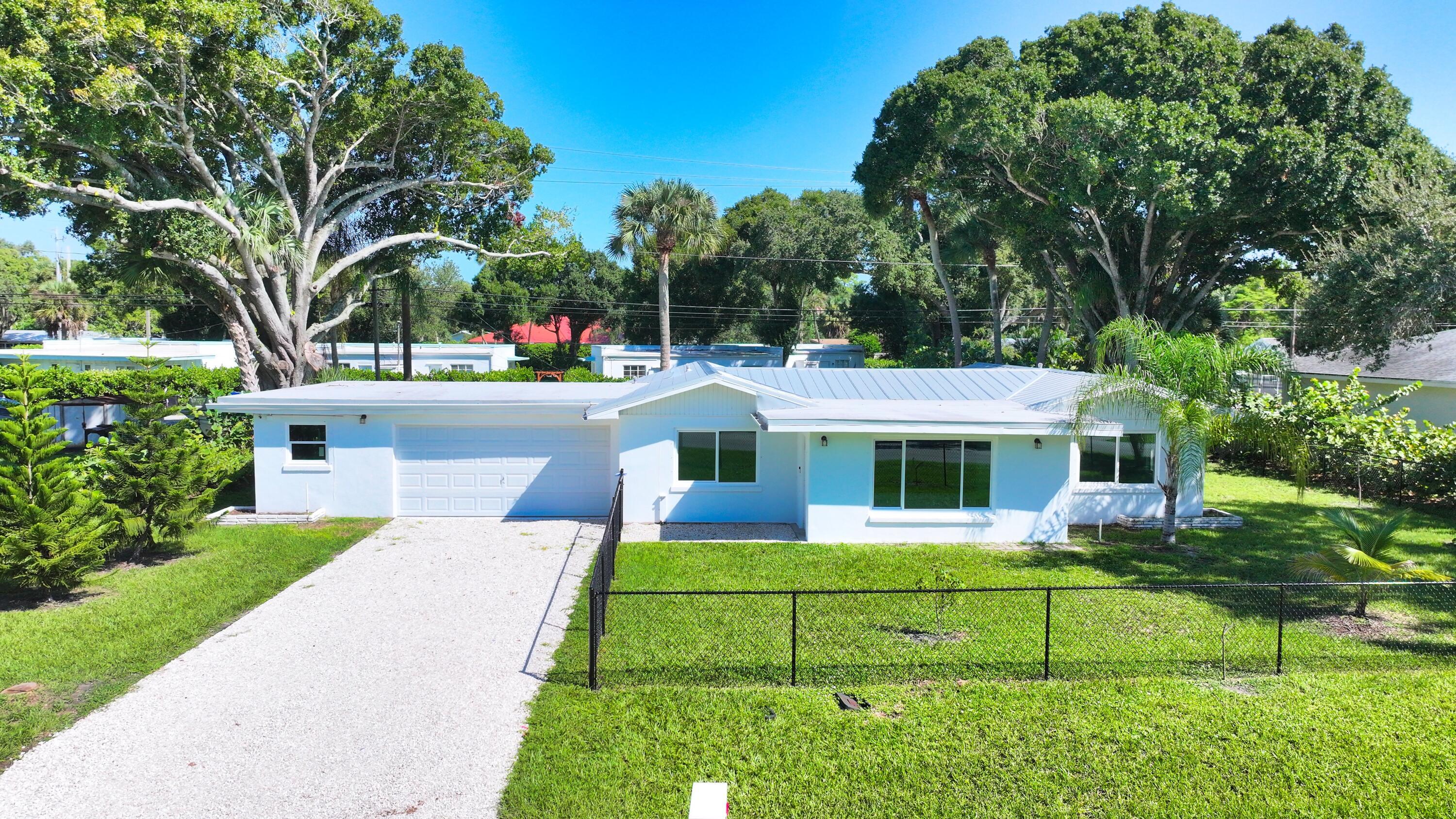 Fully renovated and move-in ready, this versatile 4 bed, 3 bath property offers exceptional flexibility for multi-generational living, guests, or potential rental income. The main home features 3 beds & 2 baths, while the attached 1 bed, 1 bath guest cottage includes its own private entrance, driveway, living area, & kitchen. Updates include renovated kitchens and baths, laminate flooring, impact, and a metal roof. Enjoy a fenced yard and oversized 2+ car garage with epoxy flooring and abundant storage. A rare opportunity combining comfort, functionality, and flexibility in Vero Beach.