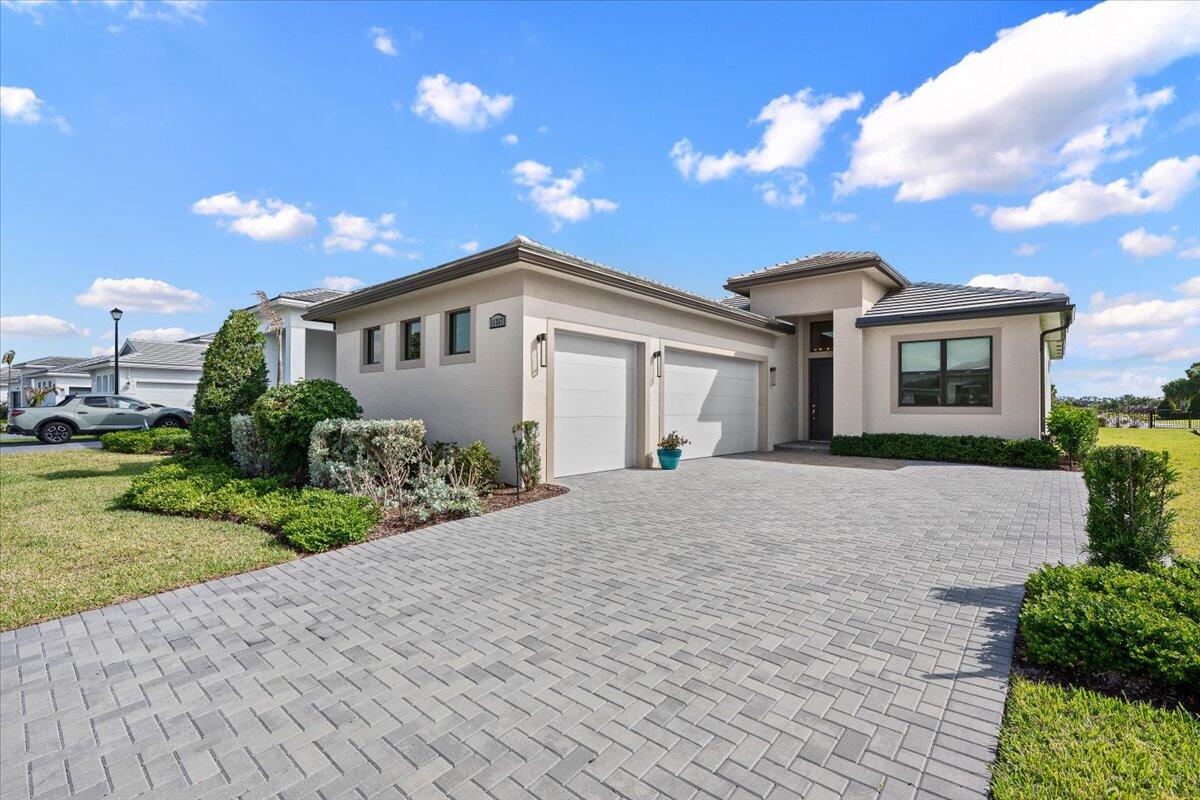 REINTRODUCED TO THE MARKET WITH EVEN MORE INTERIOR DESIGNED UPGRADES, 11357 SW Pietra Way offers elevated living within the gates of PGA Verano. Situated on an oversized waterfront lot this extended Lila model, with a rare three-car garage, combines luxury, comfort and lifestyle in one of Port St Lucie's most sought-after resort-style communities. Thoughtfully designed with a desirable open-concept floor plan, the home features two spacious primary suites ideal for guests, multigenerational living, or added privacy. Upgraded premium finishes, custom window treatments, and designer details create a warm, move-in ready feel that stands apart from standard spec inventory.  Light filled living spaces flow seamlessly for both entertaining and everyday living all enhanced   by a fenced in backyard, tranquil water views and a refined coastal aesthetic. Residents of PGA Verano enjoy a true resort lifestyle. The community amenities include 27 pickleball courts, 2 fitness centers, 3 pools, 2 HarTru Tennis Courts and spectacular clubhouse.  Situated adjacent to the renowned 54-hole PGA Golf Club with cart path access, your home is more than a residence, it's truly a lifestyle! The 40,000 sq ft clubhouse and fitness center are at your fingertips, along with an indoor lap pool. Enjoy leisurely afternoons in the bocce court, card room or attend a cooking class or wine tasting with neighbors in the demo kitchen. Relax in the saunas or unwind by one of the outdoor resort pools with cabanas. A convenient Publix is located by the front gate adding to the ease of living in this exclusive community, and a new town center is coming with shops and restaurants right outside the gate .