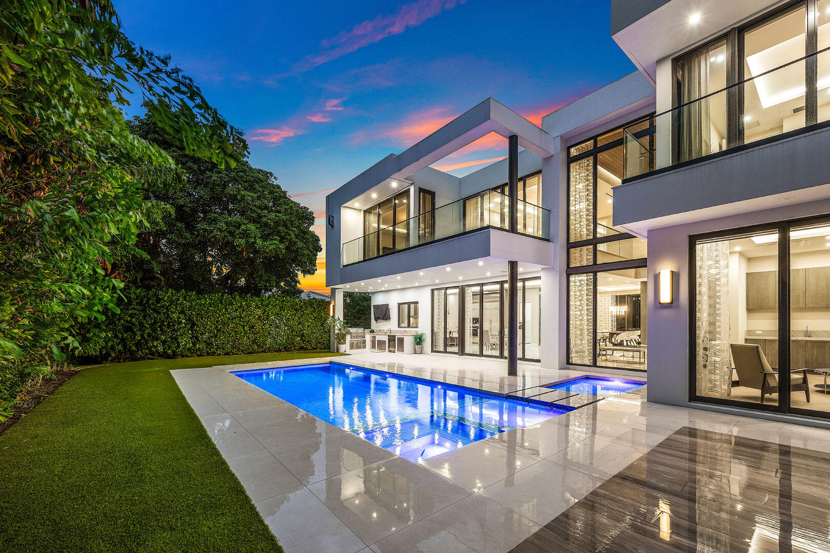 Welcome to 2391 Areca Palm Rd, a modern estate designed by BE Design and built by Albanese & Sons, nestled on a quiet street within the prestigious Royal Palm Yacht & Country Club. This newer construction residence offers over 6,000 square feet of refined living space with 5 bedrooms and 6.5 baths, showcasing exceptional craftsmanship and finishes throughout. The open-concept layout is ideal for contemporary living and entertaining, featuring soaring ceilings, expansive impact glass, and clean architectural lines. The main level is centered around a spacious great room that opens to covered outdoor areas, alongside formal dining and a chef's kitchen with Miele appliances, quartzite countertops, custom cabinetry, and a generous pantry. A private en-suite guest bedroom and a separate club room with bar and cabana bath provide flexibility for guests and entertaining.
Upstairs, a central lounge connects the bedroom suites. The primary retreat features a spa-style bathroom with dual vanities, walk-in closets, a morning bar, and private balcony access. Additional en-suite bedrooms are generously sized, many with balconies or terraces.
Outdoor living includes a resort-style pool and spa, covered loggias, and inviting entertaining areas. Additional features include a three-car garage plus a dedicated golf cart garage. Ideally located within a gated enclave near shopping, dining, beaches, and top-rated schools.