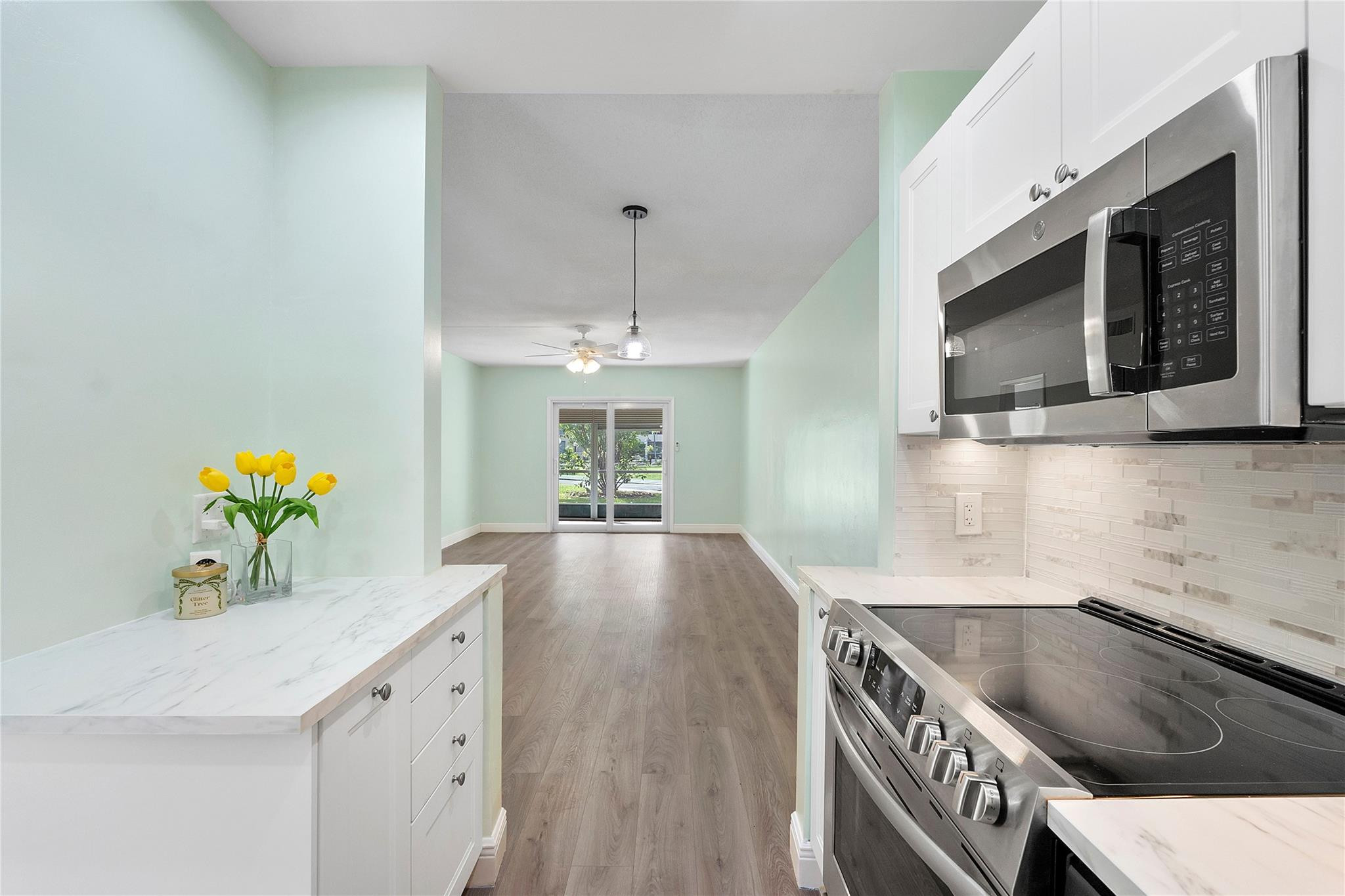 Beautifully remodeled ground floor 2 bed 2 bath condo in Lighthouse Point with assigned parking at your door. Renovated with top-quality materials, the open kitchen features stainless steel appliances and modern cabinetry. Luxury laminate floors, tile baths, and a primary bedroom with en-suite and barn doors to maximize space. Two walk-in closets and primary bath with walk-in shower and grab bars for persons with limited mobility. New impact windows and sliding door for peace of mind. Private patio with direct access to pool, clubhouse, and community areas. 55+ community with heated pool, putting green, shuffleboard, bocce, and BBQ area. One buyer must be 55+, others 18+. Perfect for seasonal or year-round living near beaches, shopping, dining, and entertainment. Low HOA and move-in ready! Association does not allow rentals. Parking space # 11
