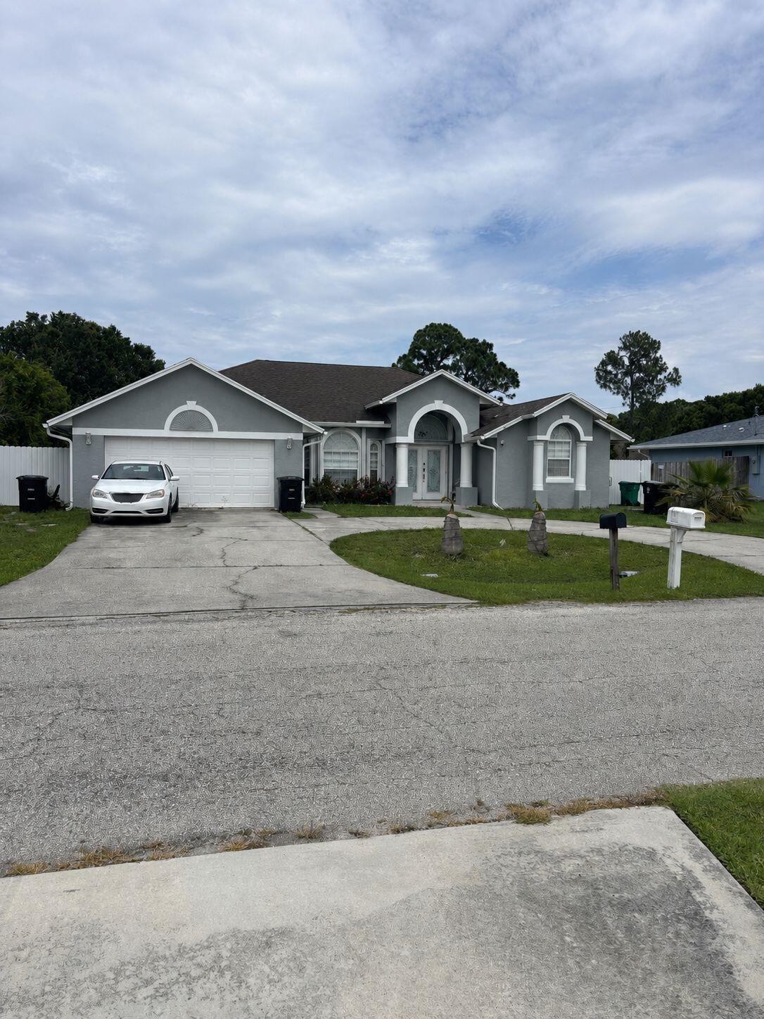LOCATION, LOCATION, LOCATION!   Beautiful property located in the heart of Port St. Lucie. Originally a 3-bedroom, 2-bath home, it now offers a total of 4 bedrooms and 3 bathrooms thanks to a separate garage conversion ideal for in-laws, guests, or potential rental income.  The home features renovated flooring, a fully updated kitchen, and one completely renovated bathroom. The buyer will also receive a completely brand-new roof before closing. Additional highlights include a saltwater pool, custom closets in the secondary bedrooms, a 2023 metal fence surrounding the property, and a large U-shaped driveway with space for approximately 7 vehicles.   The fully enclosed back patio includes upper and lower kitchen-style cabinets already installed, along with water and electrical connections ready to complete an outdoor kitchen.  Additionally, the property currently includes an RV generating approximately $800 monthly in rental income