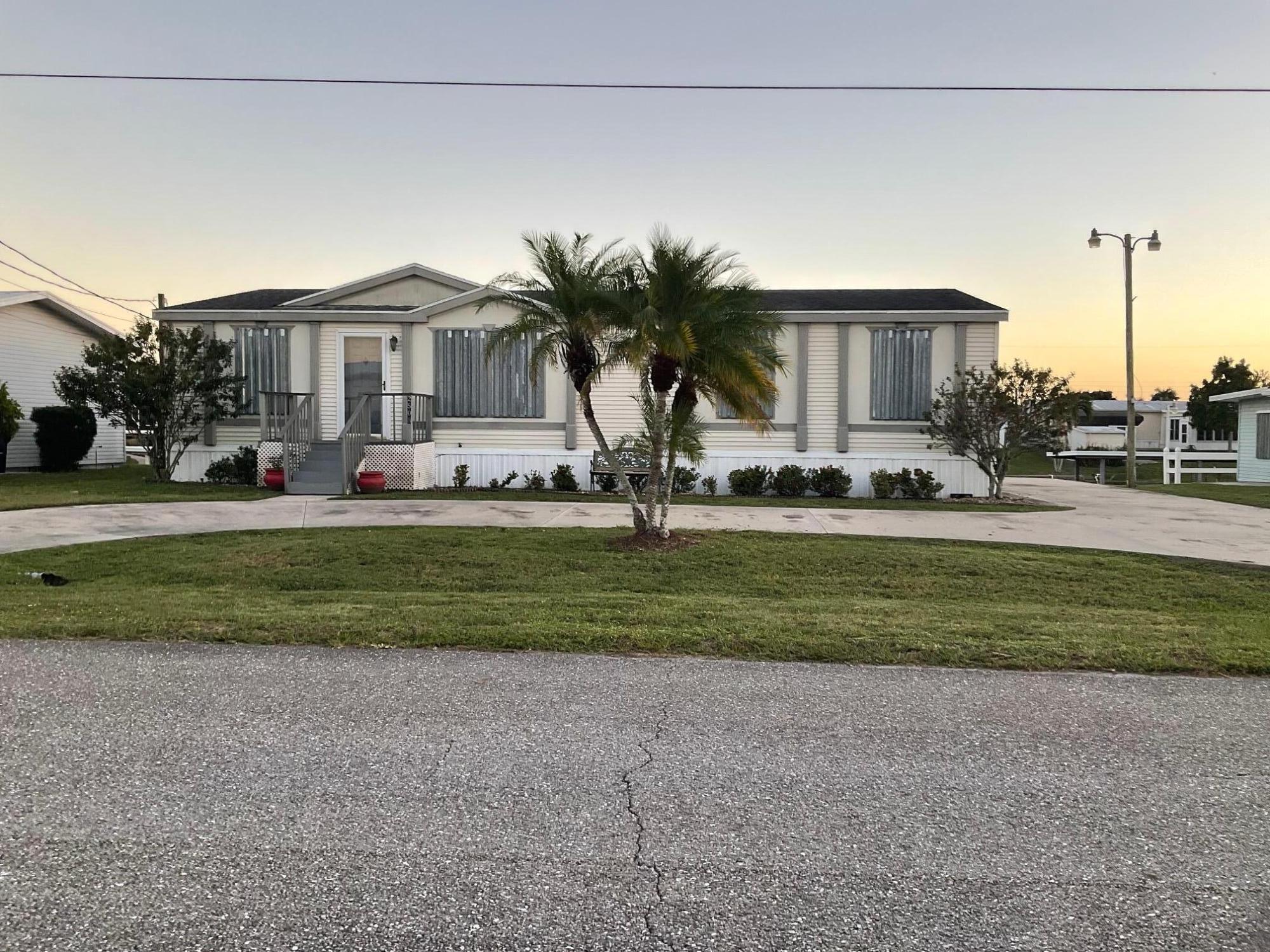 Taylor Creek isles- Lake Okeechobee access. Looking for a spacious home with room the entire Family, look no further than this 2005 3-bedroom 2 bath DWMH quality built by Palm Harbor.  Features include new Central AC 2025, aluminum seawall, exterior storage, hurricane shutters, Circle driveway with additional parking for boat or RV w/ electric hookup. Inside you'll find a large fully equipped island kitchen, tons of solid wood cabinets, Florida room overlooking the canal, split bedrooms, master suite w/ built in office, Walk in closets, and so much more! Conveniently located only 3-canal from Lake Okeechobee, close to shopping & dining! so, if you are looking for the perfect full-time Family Residence w/ room for the entire Family, or winter retreat this is the one! Call today!