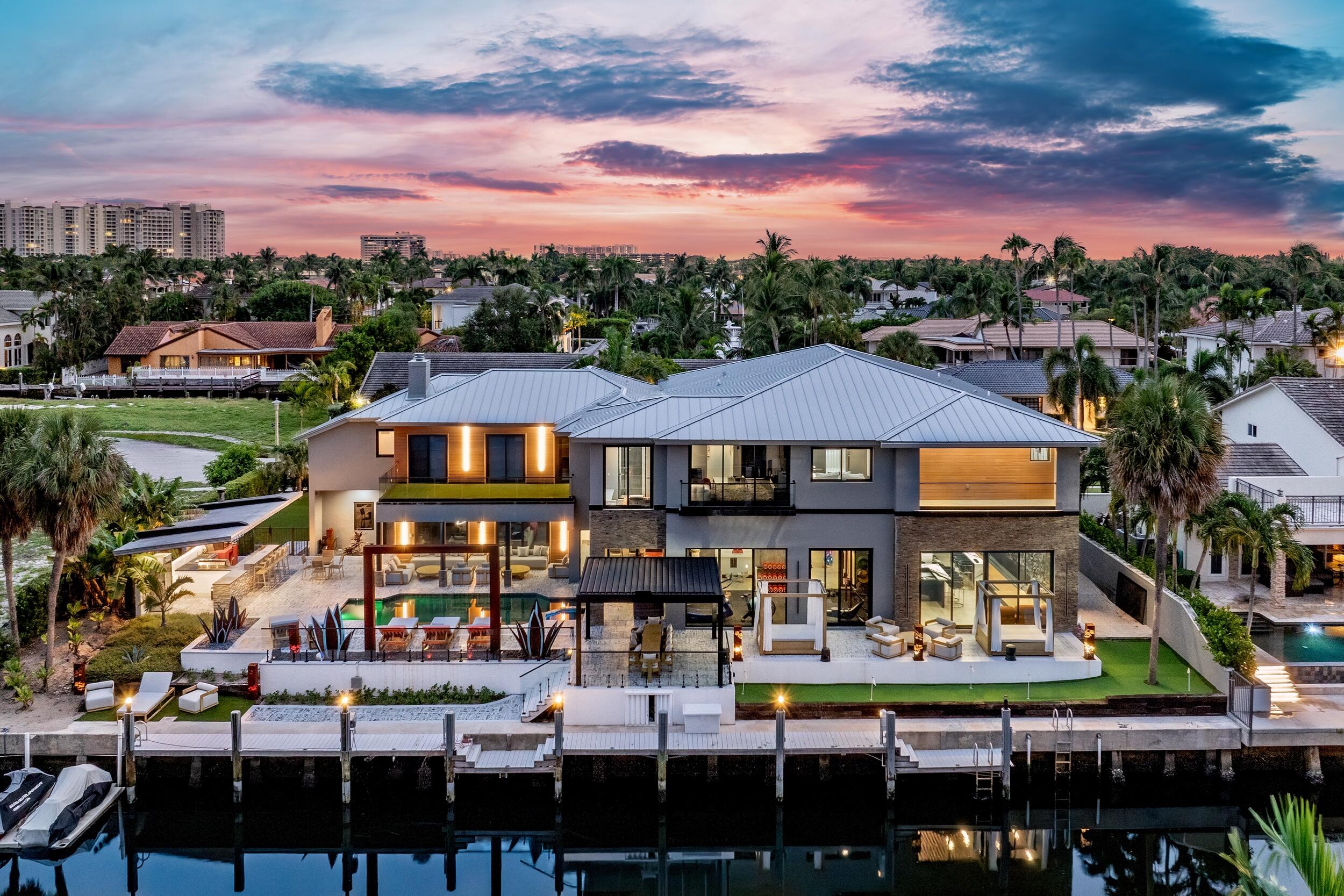 Discover 839 NE Bay Isle Drive, a newly built contemporary masterpiece in Boca Bay Colony. Spanning over 9,000 square feet on an oversized lot with 135 feet of deepwater frontage, this estate offers direct ocean access in minutes. Offered Fully furnished with bespoke custom furniture, this 6-bedroom, 8-bathroom residence redefines luxury waterfront living. Powered by natural gas with a tankless water heater, it blends cutting-edge technology and curated finishes for unparalleled sophistication. 
Enter through a glass pivot door into the Great Room, where soaring ceilings, 42'' x 42'' porcelain floors, and pool deck views captivate. The chef's kitchen boasts a Viking gas cooktop, Thermador oven, GE double oven, JennAir dishwasher, Kenmore refrigerator, and a walk-in pantry with a Samsung Smart refrigerator, all accented by sintered stone surfaces. The adjacent dining room, with a custom Walnut and Epoxy table for 12, flows into a family area enhanced by Denon sound systems throughout.
A private office with custom millwork offers serene productivity. The Lounge Room, an entertainer's dream, features a $20,000 designer pool table, duckpin bowling, 120" retractable projector screen, and a wet bar with a sink, icemaker, refrigerator, and 80-bottle wine cooler. The Fitness Center, framed by a glass pivot door and metal mesh divider, includes a Concept 2 Ski Erg, Rower, Assault Bike, heavy bag, speed bag, and poolside access with water views. A 4-car garage with Nitro tile flooring and tinted glass doors completes the main level. 
Ascend the Panda marble staircase or custom hydraulic elevator to the Owner's Suite, featuring dual walk-in closets and two spa-inspired bathrooms with a steam room, Jacuzzi, Smart Shower, granite pedestal sink, and smart toilets with remote controls, heated seats, and bidets. The guest master bathroom showcases ceiling-to-floor Panda sintered stone, while other upstairs bathrooms feature Calcutta sintered stone, smart mirrors, and pebble tile floors. A media room with a 100" TV, Denon surround system, and multicolored star ceiling delivers cinematic luxury.
The outdoor oasis features a saltwater pool, spa, wrap-around putting green, and a stainless steel summer kitchen with a new 6-burner gas grill, double side burner, refrigerator, and Italian wood-burning pizza oven, all under a heated overhang with projector screen mount. Unwind by the 15+ foot water feature, accented by Corten steel agave plants and a water sculpture, or relax under the 15x15 louvered pergola. The Trex-decked dock, with new power towers and a floating jet ski dock, perfects waterfront living. 
839 NE Bay Isle Drive epitomizes modern luxury in East Boca Raton's premier enclave waterfront neighborhood.
