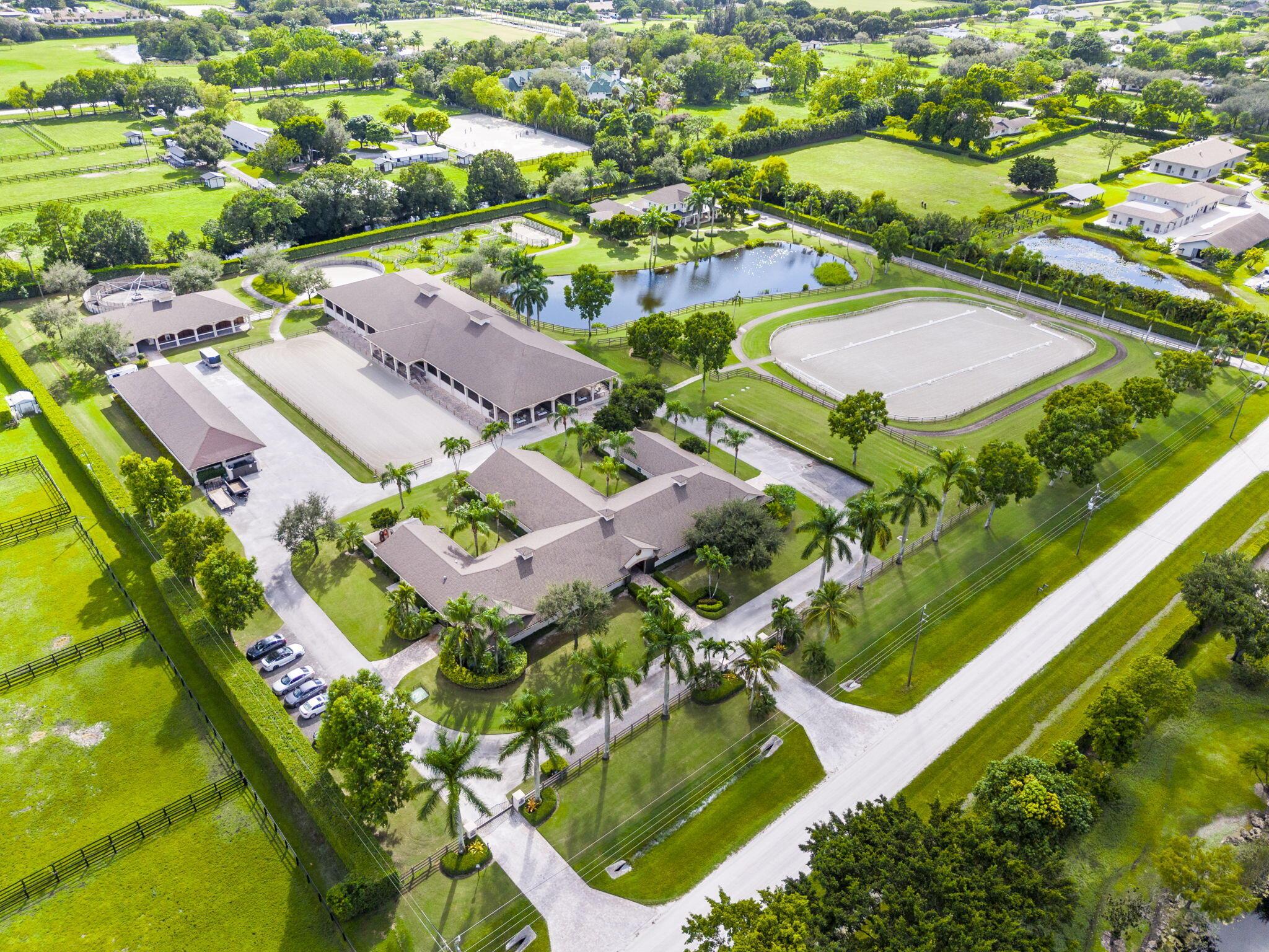Step into a truly exceptional equestrian estate where Olympic-caliber performance meets refined luxury. Set on 10.33 stunning private acres, this thoughtfully designed property offers unparalleled training facilities alongside elegant living spaces crafted to support both horse and rider at the highest level.

The centerpiece is an expertly engineered barn with 17 stalls, including a separate eight-stall barn featuring its own tack room. The barns and all amenities are impeccably maintained and beautifully appointed. Horses enjoy superior care with fans and fly spray systems in every stall, four grooming stalls, two wash stalls, multiple grooming stations, a dedicated farrier area with drive-in access, and a spacious covered equipment area for horse spa and exercise gear. Additional features include a hot walker, round pen, and seven paddocks, one of which is a stallion paddock. Ample tack rooms, equipment storage, manure management facilities, and multiple gated entrances support efficient and seamless daily operations.

The training facilities are impressive and versatile, highlighted by a large covered arena with multiple viewing areas and two additional arenas perfect for schooling and clinics. Professional-grade footing is maintained by an indoor irrigation system, and multiple tracks encircle the property, providing everything needed for comprehensive equestrian training.

The main residence is bright and airy, boasting over 5,078 square feet of living space with wood tile flooring throughout. It features a large kitchen outfitted with stainless steel appliances, including a Sub-Zero refrigerator, impact windows, and a primary suite with a relaxing sitting area and scenic views. Currently configured as a single-family home with five bedroomsthree upstairs, and 7.1 bathrooms, the layout offers flexibility to be converted into two separate living spaces, ideal for multigenerational living, guests, or trainers. Additional highlights include a spacious patio with pool, powder and laundry rooms, three AC units, a gas generator, and large storage closets.

Set amidst beautifully maintained grounds and mature landscaping, this estate blends professional equestrian excellence with sophisticated living. The entire property is surrounded by lush Clusia hedges and secure fencing, providing ultimate privacy and tranquility.   Located in Wellington, just minutes from premier horse show venues, upscale shopping, and dining, it presents a truly rare opportunity to own a private, luxury equestrian property in one of the nation's most desirable equestrian communities.