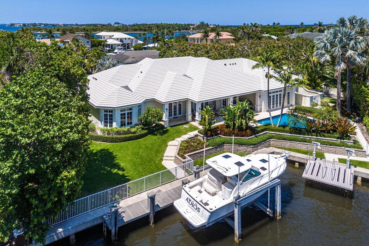 Situated on a spacious double lot over half an acre, this Ocean Ridge estate is a yachtsman's dream. With deeded beach access and membership to the McCormick Mile Beach Club, the residence boasts 118 feet of waterfront and a prime location near the Boynton Beach Inlet, with close proximity to pristine beaches. Built by renowned builder Ciro Gomez, this property spans 6,923 total square feet and features four bedrooms and four and a half bathrooms. The home exudes elegance with classic finishes, a gracious layout, and exquisite water views.  Upon entering, visitors are welcomed by a spacious foyer leading to a formal living room adorned with beautiful tray ceilings, marble floors, and a custom-designed bar. The home integrates progressive design elements and fine millwork, showcasing a formal dining room with built-in shelves for storage and entertaining, and an oversized gourmet kitchen with a breakfast nook and high-end appliances to delight the most discerning chef. 

The primary bedroom offers serene water views, tray ceilings, his-and-her bathrooms, and two large walk-in closets. Three additional guest suites complete the home, one of which is oversized with water views leading out to the pool. Seamlessly blending indoor and outdoor living, the loggia and resort-style pool are surrounded by lush landscaping for maximum privacy. The dock includes a boat lift and a jet ski lift. This estate is perfect for those seeking resort-style living close to shops, restaurants, airports, and all the amenities South Florida has to offer.