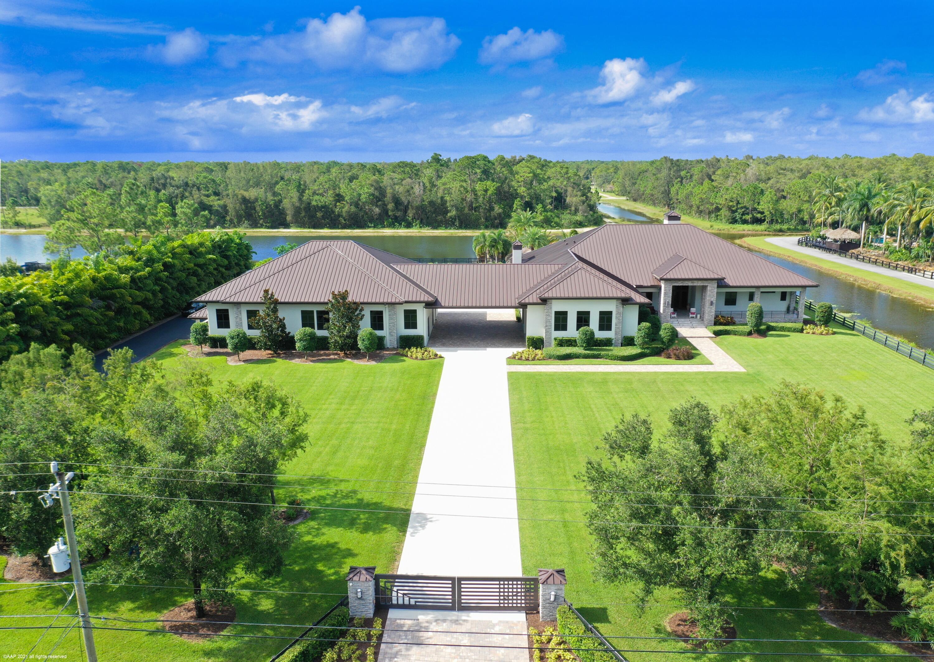 Beautiful lakefront home in the gated equestrian community of Homeland! 4 years new the home offers an open concept floorplan for ease of living with resort-like outdoor areas with stunning sunset views over the lake. The home boasts tile floors throughout, ctr-island kitchen w/ quartzite counters, gas cooking, double refrigerators, 2 fireplaces, impact windows & doors, 14' ceilings & a luxurious master-suite.  You'll love entertaining poolside with the water & fire features, summer kitchen, firepit, tiki bar & dock. The main house  is 4,845sqft/ac & mancave is 1,220sqft/ac. Also under air are the firing range & dog kennels. The RV/hangar garage & workshop with 14'x24' hangar door offer the ability to house up to 17 cars on property. A must see for the active family w/ all the toys! Summary of Additional Home Features:

An additional 2,735 sq.ft. of possible living space left unfinished for your custom buildout in the secondary building - perfect for guest house, in-law quarters or home business - endless possibilities.

Central vacuum
Sonos Sound throughout 
26 security camera system
16' entry ceiling, 14' in living areas
2 Wood & Gas fireplaces
Staking sliding doors opening to 16'
Office with custom built-ins

6 burner Thermador cooktop with griddle
Pot filler, double ovens & refrigerators
2 Kitchen sinks, wet bar with wine cooler
Summer kitchen with bbq with gas line, 2 burner, refrigerator & sink.

Laundry room: LG washer & Dryer, refrigerator & sink

Master Suite: electric blinds, wet bar with sink & refrigerator, dual vanities, dual shower heads, 2 large walk-in closets one with built-in Liberty safe.
 
 House garages have 16' x 12' doors - 8 car capacity.

The Pool:
50' x 25' saltwater party pool - slopes to 4'.5"
Pebble tec surface with glass tile. Gasline for pool heater installation, 4 firepits, 8 illuminated water spouts, 6 LED lights - all automated by cell phone.
Hot tub on master side of screen patio along with cabana 1/2 bath & outdoor shower.
Patio & pool deck with sound system.  
12'x24' sun deck.
Tiki bar with sink & refrigerator. Both the Tiki hut & dock have running water & electric, speakers and ceiling fans.  20' x20' Tiki dock extends 40' into the water.
Firepit with gas line.  Multiple Tiki torches.


Secondary Building:
1,220 Sq. Ft. Mancave/club room with 1/2 bath & kitchenette area with sink & refrigerator. 
Air-conditioned 6' Single lane firing range with ballistic sound buffering mats & automated target retriever & exhaust system.
Mancave & firing range act as hurricane safe rooms with poured concrete walls & 10" concrete ceiling.

Workshop / Garage: 9 car capacity, 50 Amp Motor home hookup. Room for 9 cars, or a helicopter with 14' x 24' hangar door on remote & 18' ceilings.
Air-conditioned Dog kennel wing with 4 kennels and room to add more, plus vet room & isolation rooms with stucco walls. (The Dog kennels are not for commercial use). 1 camera in isolation room and 2 in kennel area. 95' x 25' grass dog paddock with hose bib. Kennel has a drainage system to dual 500 gal tanks with a lift to the main drain field.

11 televisions with DirectTV
3 Zones AC in the house.
3 Mini splits in dog kennels - Dykin
1 Mini split in gun range - Mitsubishi 
Mancave has own AC Compressor - Courrier

Electrical:
Exterior Lighting Package - all on timers.
Landscape up-lighting, front & rear columns of house, front entry, front steps, gate columns, soffit downlights & soffit outlets for holiday lights.
600 Amps to main house
No exposed electrical conduit in hangar garage - run inside the block.

Generac 100KW whole house generator - 1000 gallon tank.  System is linked to cell phone.

The house is stem-wall construction & 4' above street elevation. 2' pitch to the road. All down spouts drain to the canal or lake.
Front exposure is south & the rear is north. 

Circular driveway with two electric gated entries. 

2,735 sq.ft. of unfinished area ready for buildout:
Loft area hangar garage (1,534sq.ft.) and adjacent 40' x 30' bonus room above the portico breezeway (1,200sq.ft.). Water & sewer is stubbed. 

A detailed list to be provided at showings. 

All sizes & numbers are estimated and the responsibility of the buyer to confirm in the due diligence period.