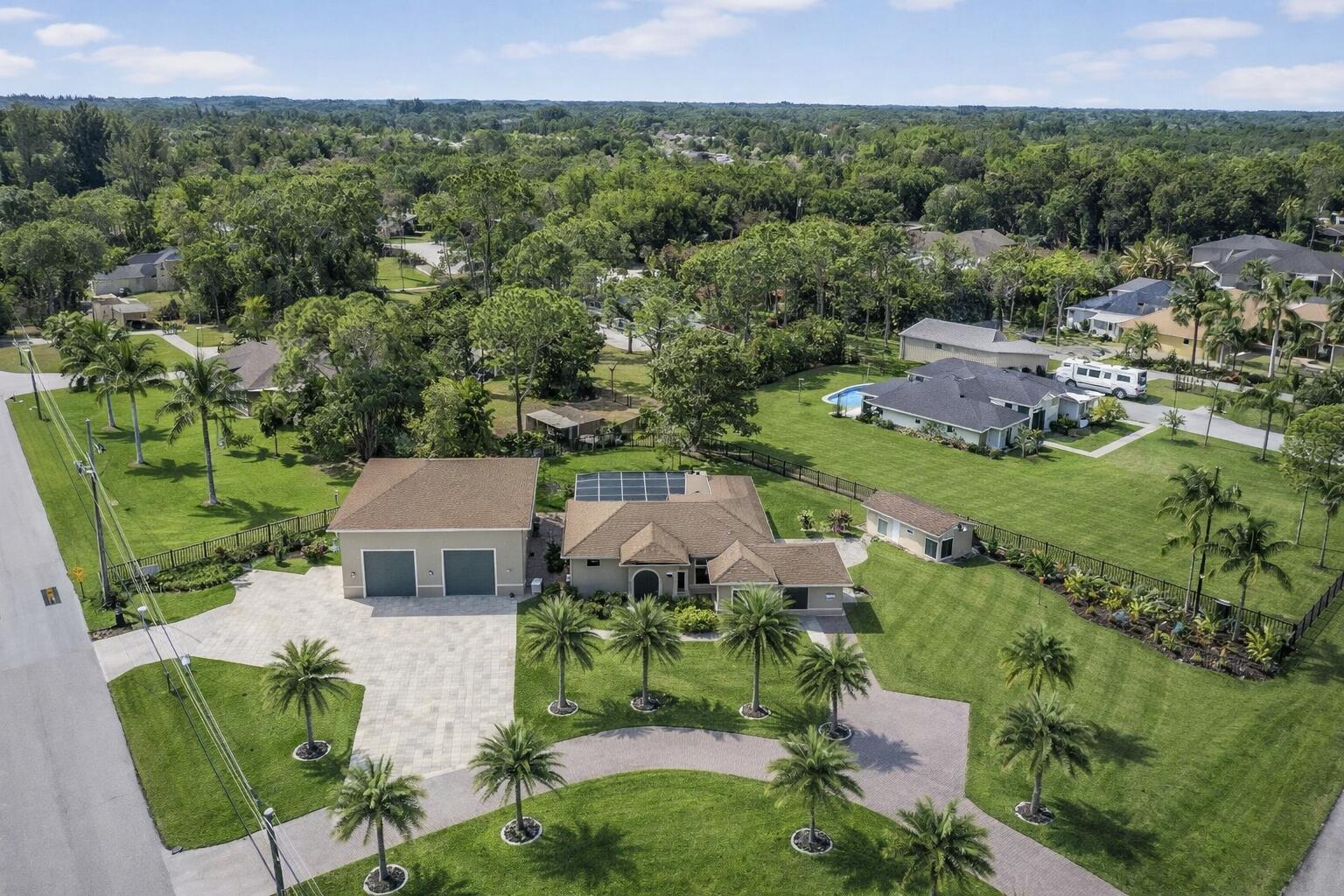 Welcome to The Acreage in West Palm Beach, where you can enjoy a peaceful, country lifestyle just a short 15-minute drive from Palm Beach International Airport and 25 minutes from downtown West Palm Beach! The large lots and family-oriented neighborhoods emphasize youth sports and community spirit. With no HOA restrictions, it's common to see residents with horses and livestock.  Nestled on a sprawling 1.42 acres, including a main house and a guest house, making it perfect for multigenerational families or potential rental income. The Main house is boasting approximately 3,163 sq ft of living space, the home features 4 bedrooms and 3 full bathrooms, with soaring vaulted and cathedral ceilings that amplify the sense of grandeur throughout . Step inside to discover a seamless open floor plan adorned with porcelain tile flooring, flowing effortlessly from the formal dining room and family room to the theater space and Florida room. The heart of the home is the chefs kitchen , complete with a massive quartz island and bar, abundant storage ,and top tier finishes that reflect meticulous , no expense spared updates . Retreat to the luxurious  master suite, where French doors open to the heated gunite  pool and spa  in a screened in patio - your private oasis for relaxation  and al fresco gatherings. Outside, the expansive  grounds are dotted with fruit trees and offer ample space for RV or boat parking and room for at least 10 parking spaces in the paver- block driveway.The extraordinary guest house-former -garage offers nearly 3,000 sq ft of luxury living space . THE CENTERPIECE ? A jaw dropping 1,200 sq ft man cave  featuring a state-of-the-art $200k home theater system included with purchase, perfect for immersive movie nights -or easily converted back to accommodate an RV or boat. As you step inside to discover a brand new -kitchen, never been used full kitchen with a generous quartz counter top island and bar that flows seamlessly into the living area. Porcelain  tile graces the floors throughout , while convenient laundry room and full bath complete the main level. Upstairs, two oversized bedrooms await , including master suite with its own soaking tub. This is a unique property and a MUST SEE for yourself!
