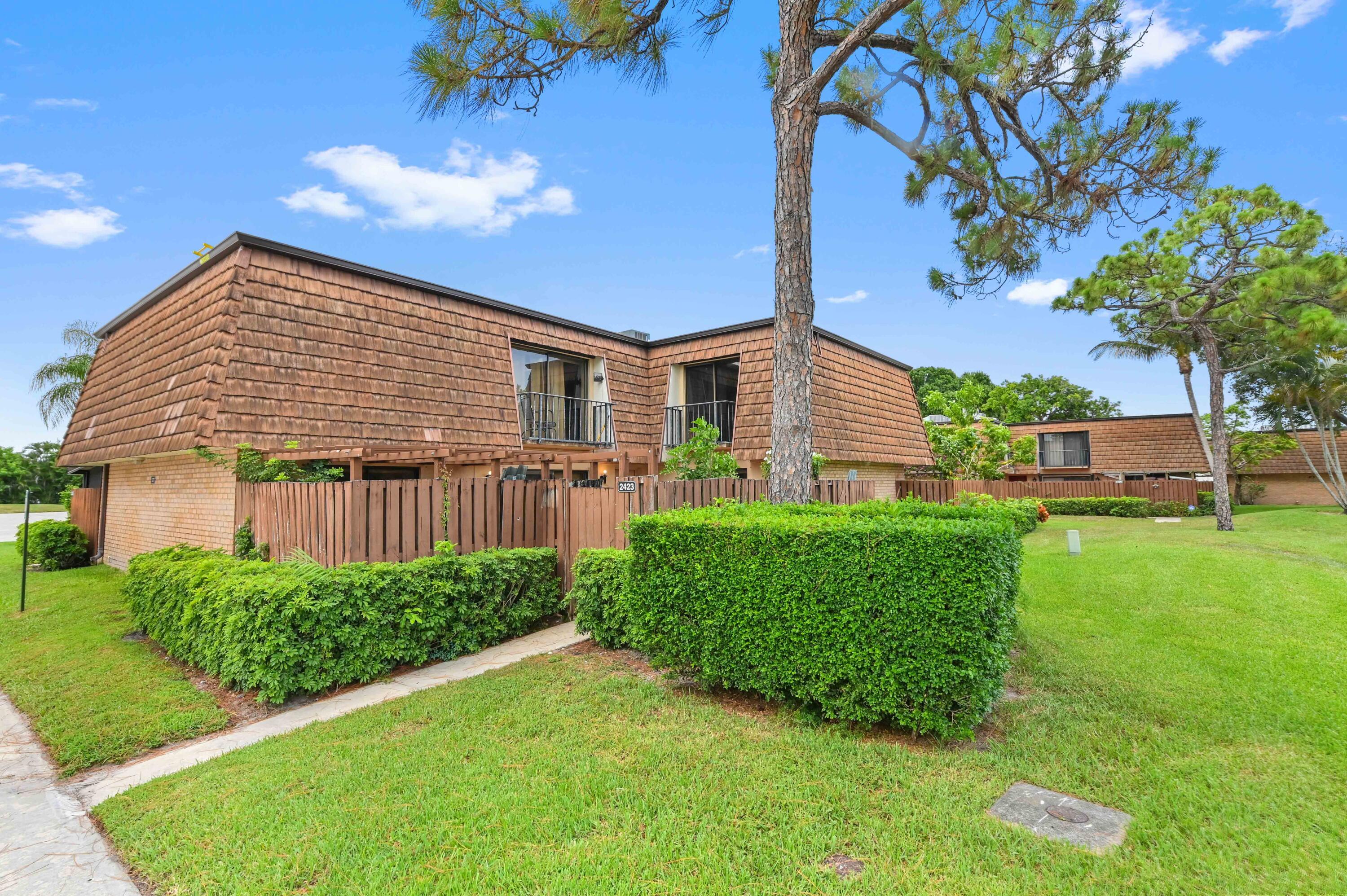 Experience the perfect blend of comfort and convenience in this charming 3-bedroom, 2.5-bathroom townhome, ideally situated in the well-maintained community of Sherwood Lakes in Greenacres, FL. Step inside to a cozy living room, enhanced by tasteful mirrors, creating an inviting atmosphere. The main level offers exceptional functionality, featuring a convenient half bathroom with laundry. and a versatile bedroom that can serve as a guest suite, home office, or private retreat. The galley-style kitchen, complete with ample cabinetry, provides seamless access via a sliding door to your private, fully fenced front patio - perfect for enjoying your morning coffee or an evening breeze. Ascend to the upper level where two additional spacious bedrooms await, including the tranquil main bedroom. This private sanctuary boasts a generous closet and an ensuite bathroom with dual sinks, offering both comfort and practicality. Both upstairs bedrooms also enjoy access to a charming porch, providing a lovely spot to unwind. Beyond your doorstep, the Sherwood Lakes community truly shines, offering residents a host of resort-style amenities such as a swimming pool, tennis courts, basketball, racquetball, jogging trails, and a playground. Located just minutes from Greenacres' finest shopping, diverse dining options, and much more, this townhome offers a fantastic opportunity for a vibrant and convenient South Florida lifestyle.