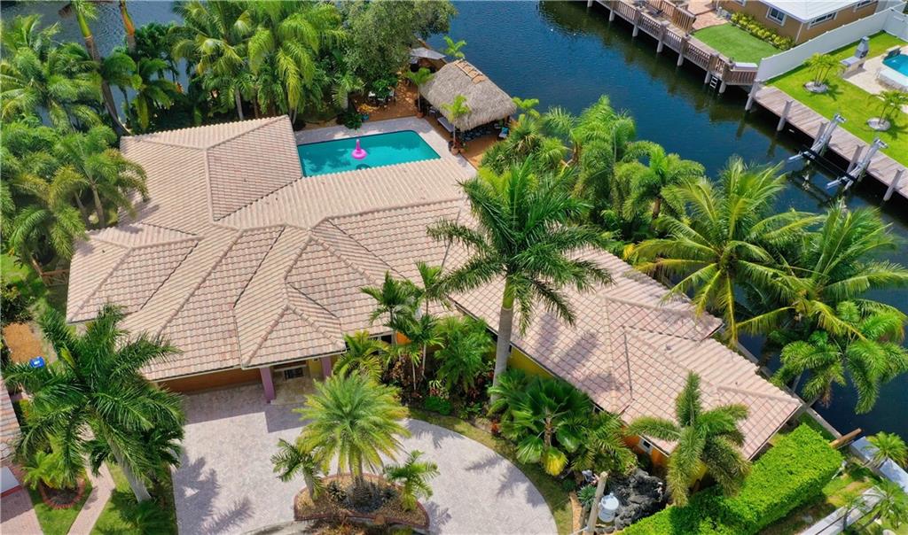Spectacular, Lush, One of a Kind Waterfront Estate property w/ Tropical expansive decks surrounding Pool and poolside Tiki Hut, short walk to beautiful Beaches, Restaurants and LBTS Town Square. Contemporary style w/ 4 lg bedrooms /3 lovely baths, triple split plan. 2 amazing Master Suites: #1 = 1000sqft w/ 2 huge California walk-ins / Royal Master Bath, #2 = Large, en-suite w/ Pool view. Polished Marble and Wood Floors throughout the home. Stylish Kitchen w/ panoramic property views, open to Spacious Family Room. Whole house Generac w/warranty. Impact Windows / Doors, Custom Front Door, Garage impact door, new Level 2 Charging Station. Point lot, 240 ft of waterfront, 55 ft dock w/ electric & water, a Boater's Dream! Located on a cul-de-sac in The Landings, ULTIMATE Privacy, A RARE FIND!