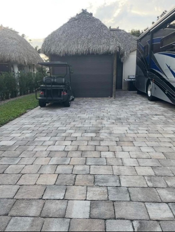 Welcome to your tropical RV oasis! Rare find combining comfort, style, and resort-style living! Enjoy the impressive 30’ x 15’ tiki hut with electric shutters and mosquito screens, installed 2023, ideal for relaxing or entertaining. Custom shed includes: Murphy bed, full bathroom w shower. Extra storage for ultimate convenience. Lot comes fully furnished with a living room set, bistro table,high-end American teak dining table with 6 chairs (invoice available). Golf cart with brand-new batteries is also included! Room to expand with options to add a rear extension or balcony for even more outdoor living space. Nestled amid lush tropical landscaping in a friendly community, this property is turnkey and ready for your RV lifestyle, whether as a seasonal escape or your full-time paradise!