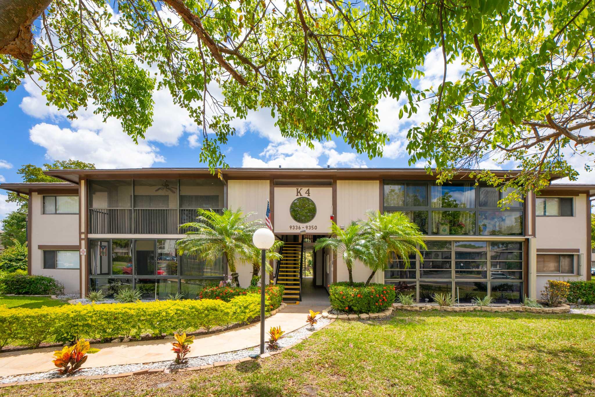Completely Remodeled First Floor Condo Located In Kings Point In Tamarac! Beautiful 2 Bedroom 1 Full Bath with no stairs!  Main bedroom is oversized for a king size bed and offers a  HUGE walk in closet in lieu of the 2nd full bathroom. 2022 laminate flooring , paint , A/C, fridge, washer & dryer. Bathroom  has stylish tile work, shaker cabinets & quartz tops. The 42" upper kitchen cabinets are perfect for the chef. Living room is large & open to the kitchen & dining for all your entertaining. Enjoy a game of cards,bunco or mahjong in your sunroom overlooking the peaceful, mature landscape. Kings Point Clubhouse has over 50 groups for you to be a part of, theatre, tennis, pickleball, pools, fitness and so much more! Hop on the community bus for all your fun! Resort Style Living! Must See!
