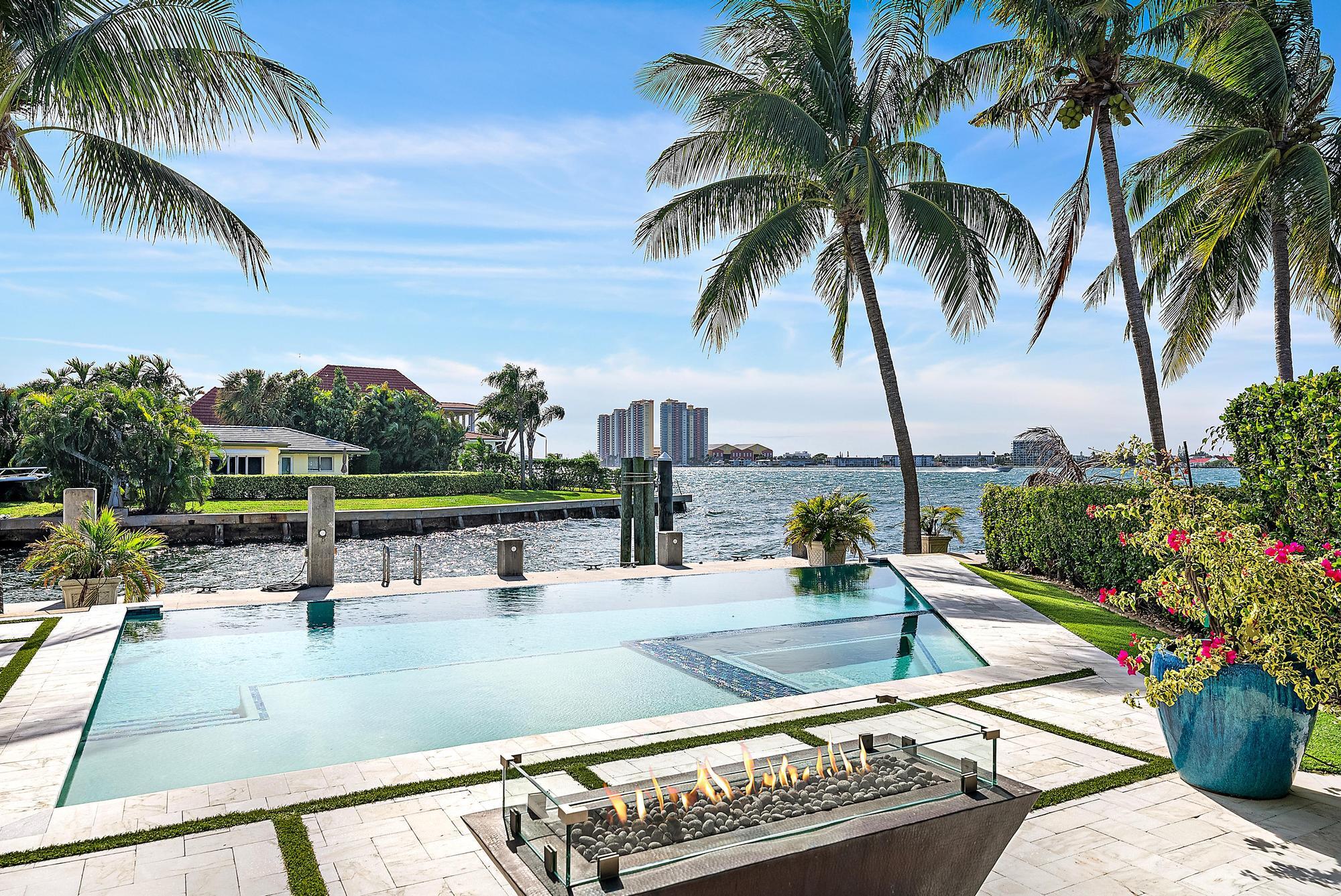 First time on the market, the view truly says it all.  This exceptional waterfront home was thoughtfully designed to maximize views of the intracoastal. Offering 4217 sf of light-filled living space (6014 total SF), this sophisticated residence blends elegance, comfort, and the very best of South Florida waterfront living.  A private elevator leads to the upstairs primary suite, a serene retreat showcasing spectacular water vistas. Two additional guest suites up and a fourth on the main level provides ideal flexibility. With an impressive 153' of waterfront and a 2014 concrete dock and seawall w/batter piles, this property is perfectly equipped for the serious boater- 5 min to inlet. Features include a 90' dock w/ power & water, a 28,000 lb hi-speed Neptune lift to fit 50' boat. Basin for a 90' boat, 9' depth @low tide. Outdoors, an infinity-edge saltwater pool & spa overlooks the intracoastal, where stunning sunsets become part of your everyday life.  Designed for effortless entertaining, this home embodies the very best of Singer Island, a peaceful enclave with quick access to luxury shopping, world-class dining, pristine beaches, and PBI airport.   A rare offering for the discerning buyer seeking an extraordinary waterfront lifestyle.  Additional features include a Tesla charging station, an auto lift in the garage that allows for an extra vehicle, and meticulous maintenance throughout a true blend of modern convenience, coastal luxury, and exceptional boating amenities.