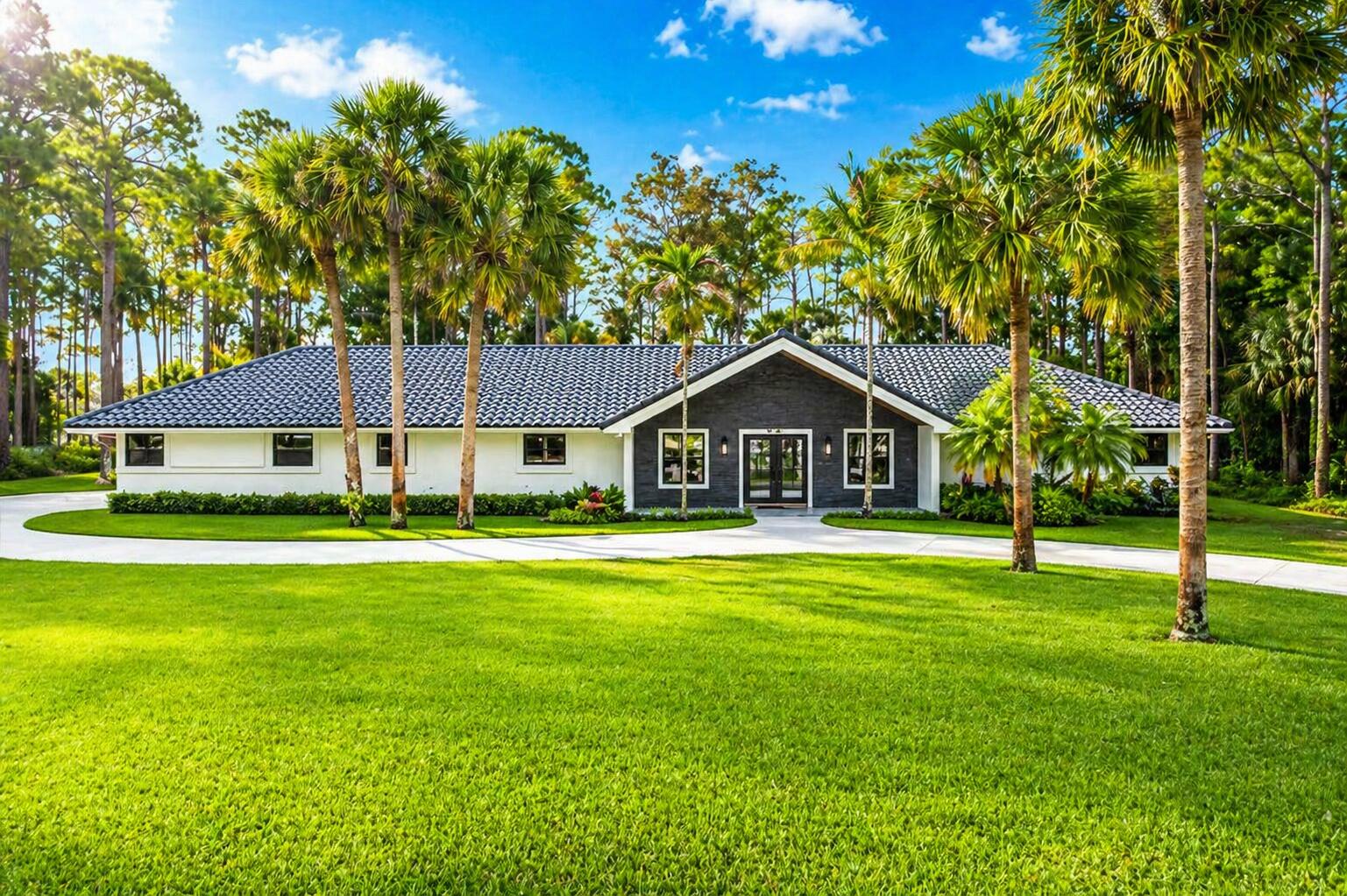 Experience exquisite luxury living on 2.1 acres in the tranquil neighborhood of Paddock Park, ideally located in the heart of Wellington renowned for its world-class equestrian lifestyle, all A-rated schools and vibrant community events. This beautifully redesigned masterpiece offers the perfect blend of sophistication and comfort featuring top-of-the-line total interior renovations, newer exterior improvements, all set on an expansive private lot you will love to call home. This residence showcases 5 spacious bedrooms, 4.5 bathrooms, and a truly exceptional backyard designed for entertaining and everyday relaxation. Inside, a bright and open floor plan is enhanced by high-end finishes and thoughtful designer touches throughout. At the heart of the home is a stunning gourmet kitchen complete with state-of-the-art Thermador appliances, custom cabinetry, modern quartz countertops, and an oversized island perfect for gathering. The lavish primary suite serves as a private retreat, featuring a spacious walk-in closet, a spa-inspired bathroom with dual floating vanities and large glass shower. This home features newer and impeccably maintained mechanical systems and household appliances, including A/C units (2021-2024), water heater (2021), impact glass windows and doors providing peace of mind for its new owner. Step outside to your own resort-style backyard oasis complete with pool, deck and fire pit designed for lounging, family fun and entertaining. The outdoor kitchen includes a built-in BLAZE grill, bar seating, and plenty of space to host BBQs, birthday parties, game days and holidays year round in the perfect South Florida weather. Surrounded by lush greenery and mature trees, this estate offers a serene, park-like setting with room for gardens, recreation, building additions and endless possibilities. Enjoy plenty of space and privacy with room for RV and boat parking plus the versatility to add onto or customize the property all within a subdivision that has no HOA fees or restrictions in one of Wellington's BEST communities!  Living in Wellington offers a lifestyle that blends elegance, space, and year-round outdoor living in one of South Florida's most desirable areas. Known as the Winter Equestrian Capital of the World and home to the renowned Winter Equestrian Festival, Wellington delivers a unique energy while still maintaining a peaceful, family-friendly atmosphere with top-rated schools including the highly anticipated Wingrove Academy slated to open in August 2028 developed by ElevateED and backed by Related Ross, the 45-acre campus will feature a strong focus on STEAM, sustainability and athletics near scenic trails, and beautifully maintained parks. Wellington is ideally situated just outside of West Palm Beach, one of South Florida's fastest-growing hubs, residents enjoy effortless access to a lively dining, shopping, and entertainment scene. Spend evenings along Clematis Street or at Rosemary Square, and explore premier cultural venues like the Norton Museum of Art, Henry Morrison Flagler Museum, and the Kravis Center for the Performing Arts. For golf enthusiasts, the area offers an impressive selection of highly regarded courses including Wellington National Golf Club, The Wanderers Club, PGA National, Bear Lakes, Breakers West, Trump International and Lost City at Atlantis delivering premier playing options. Beyond golf, residents also enjoy being a short drive away from pristine beaches and a variety of attractions including the Palm Beach Zoo, Cox Science Center and Aquarium, Mounts Botanical Garden, and Okeeheelee Nature Center. With convenient access to I-95 and the FL Turnpike, commuting and travel are effortless, connecting you to nearby cities like Palm Beach Gardens, Delray Beach, Boca Raton, and Fort Lauderdale. Residents are also just minutes from Palm Beach International Airport, have access to Fort Lauderdale-Hollywood International Airport, and can take advantage of the new Brightline high-speed train providing service between Miami and Orlando. This prime location delivers a lifestyle that is both peaceful and connected, schedule your private showing today to experience it firsthand.