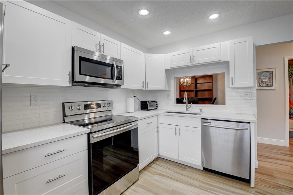 Desirable Pembridge location in gated Lakes of Delray 55+ community.  2/2 with elevator on 2nd floor.  2021 improvements include kitchen cabinets, counter tops, sink, disposal;  both bathrooms have new toilets and vanities.  Gorgeous porcelain wood-grain floors throughout.  No carpet.  2021 new electrical outlets and panel.  Vaulted ceiling adds height and space. AC 2018. View from balcony allows partial view of lake across the way.  Full size w/d and additional storage in laundry room.  Satellite pool near the building or go to the main club.   Tennis, pickle ball, card rooms, satellite pools, main club pool; 10 minutes to the beach!  Come join your friends.  Showings begin Saturday, March 12th, 11AM-2PM, by appt only.