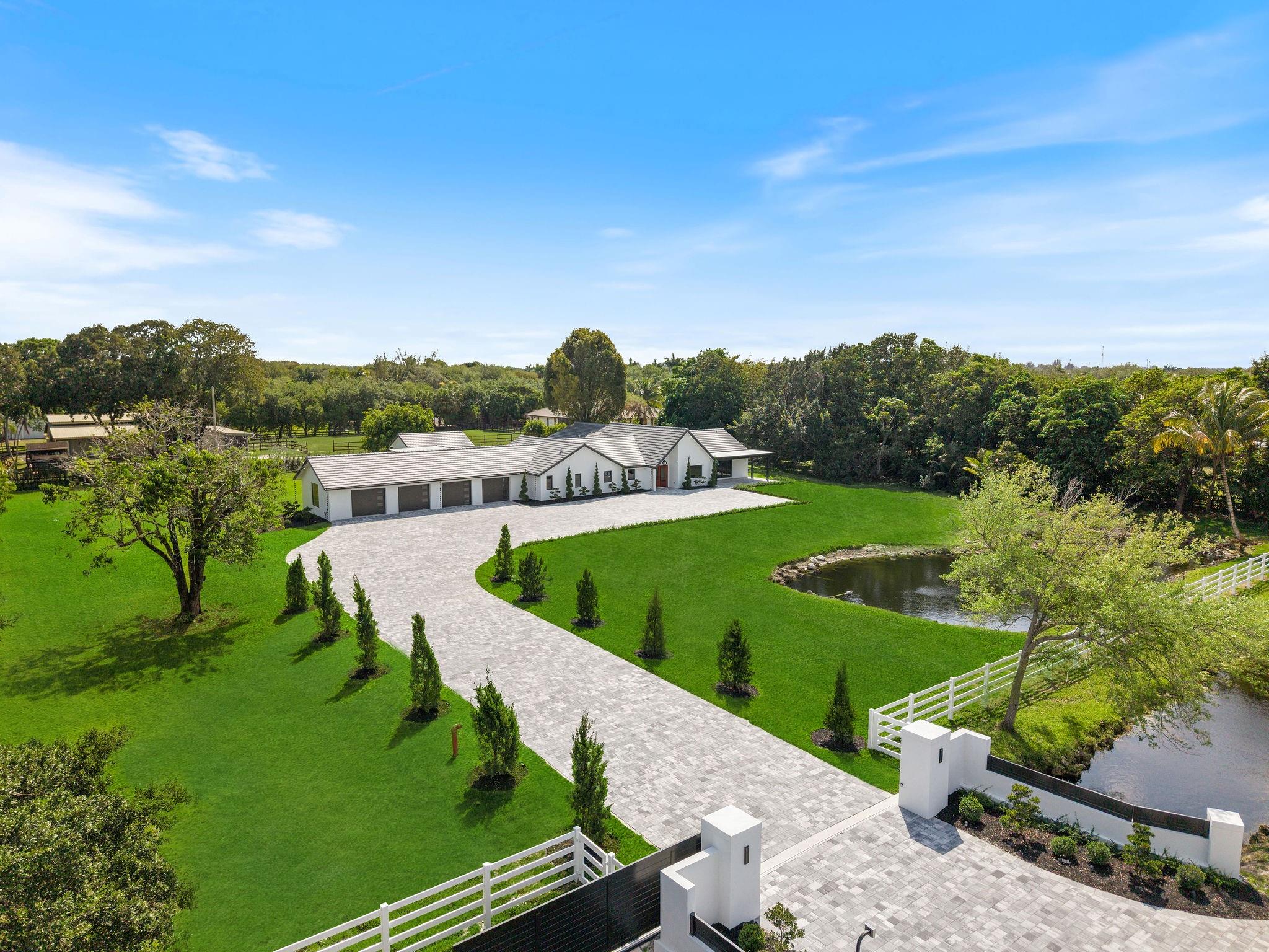 Welcome to an ultra-luxury estate in prestigious Sunshine Ranches, sitting on 2.2 acres. Fully renovated with no expense spared. This masterpiece features a brand-new roof, new impact windows, a redesigned driveway, and a private gated entrance for maximum exclusivity. The main residence offers 5 spacious bedrooms, 5.5 spa-like bathrooms, an office, and a versatile laundry/utility/mudroom/pantry plus a 1/1 pool house. Fully equipped smart home system & security cameras. The outdoor oasis boasts a new pool, gazebo, and summer kitchen. Inside, porcelain wood-look floors, Taj Mahal countertops, custom cabinetry, and Thermador appliances create a chef’s dream kitchen. This turnkey estate offers unparalleled luxury in a community home to celebrities & industry leaders. (These are real photos!)