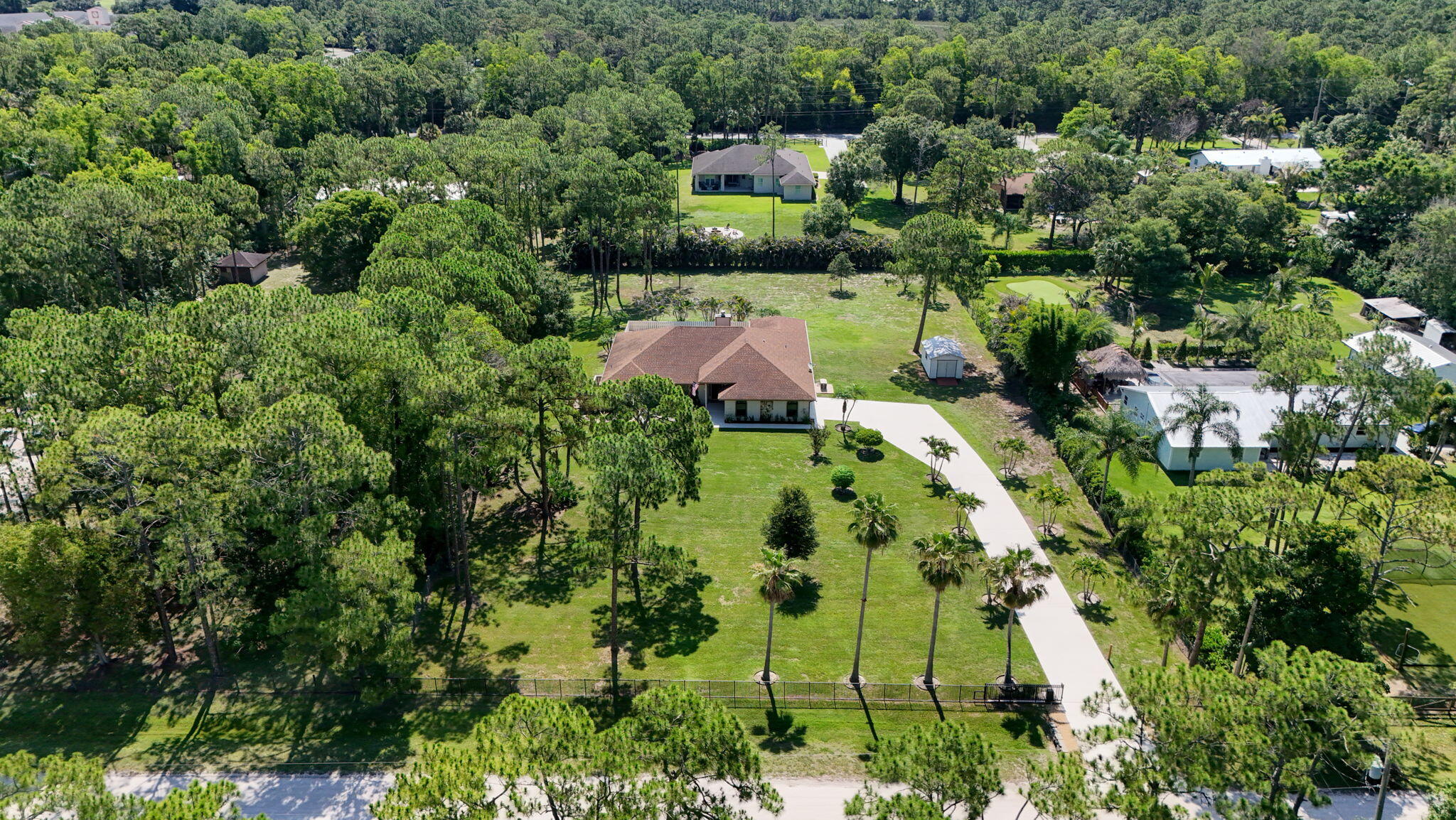 Welcome to your own private tropical retreat in the heart of Jupiter Farms. Nestled on 1.25 beautifully landscaped areas and surrounded by mature trees, this meticulously maintained single-story pool home offers the perfect blend of privacy, comfort, and modern upgrades. Featuring 4 bedrooms, 3 bathrooms, a 2-car garage, and nearly 2,300 SF of living space, this exceptional residence boasts formal living and dining rooms, expansive gathering areas, and a thoughtfully renovated kitchen designed for both everyday living and entertaining. The luxurious primary suite serves as a private sanctuary, complete with a spacious walk-in closet and beautifully updated spa-inspired bath.  Designed for effortless indoor-outdoor living, this beautiful home showcases an expansive covered and screened patio, in-ground open pool, fully fenced grounds with lush landscaping and abundant space to relax or entertain. Interior highlights include tile and wood flooring throughout (no carpet), stainless steel appliances, updated bathrooms and lighting, impact windows and whole house generator for added peace of mind.  Located in the highly sought-after Jupiter Farms community, residence enjoy the freedom of NO HOA fees and no restrictions on trucks, boats, RVs or recreational vehicles. Walking distance to A-rated elementary school AND  minutes from Jupiter's pristine beaches, championship golf courses, upscale shopping and acclaimed dining options.  Don't miss this rare opportunity to enjoy country-style living with modern conveniences and exceptional privacy in one of Jupiter's most desirable communities.