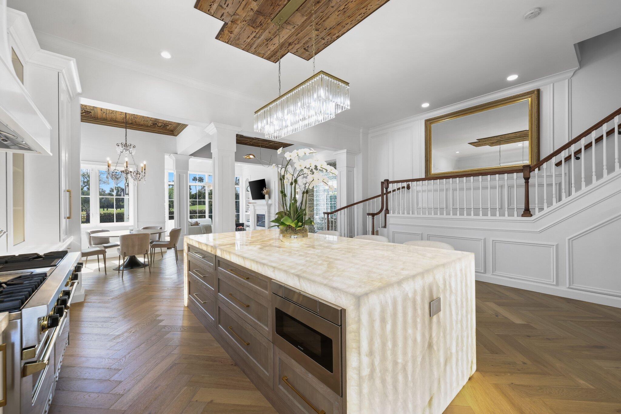 Rarely available and truly exceptional, this is one of only six single-family residences directly bordering the golf course at the prestigious Boca Raton Resort -- and the only one extensively reimagined with designer-level finishes throughout. Perfectly positioned at 340 E Royal Palm in the heart of East Boca Raton, this residence offers the ultimate blend of privacy, prestige, and walkability -- all with the extraordinary advantage of no HOA. Inside, the home showcases museum-quality materials and craftsmanship at every turn. Duchateau hardwood flooring flows throughout, including Herringbone Chaparral downstairs and striking 9.5'' straight planks upstairs. The grand foyer and primary bath are clad in natural Namibia marble, creating a timeless and sophisticated first impression. The kitchen is a true statement piece, featuring Cristallo quartzite countertops with dramatic backlit illumination, custom white oak cabinetry, and refined architectural detailing. Bespoke wood trim and ceiling treatments elevate every living space, while impact windows and doors, including a solid mahogany impact front entry, provide both beauty and peace of mind. Designed for those who appreciate elevated finishes and a resort-adjacent lifestyle, the home offers sweeping golf course views without the burden of condominium restrictions or high association dues. Opportunities to own a private golf course estate in this coveted enclave are extraordinarily rare, especially one finished to this level of detail and design. A distinctive offering in one of Boca Raton's most desirable locations.