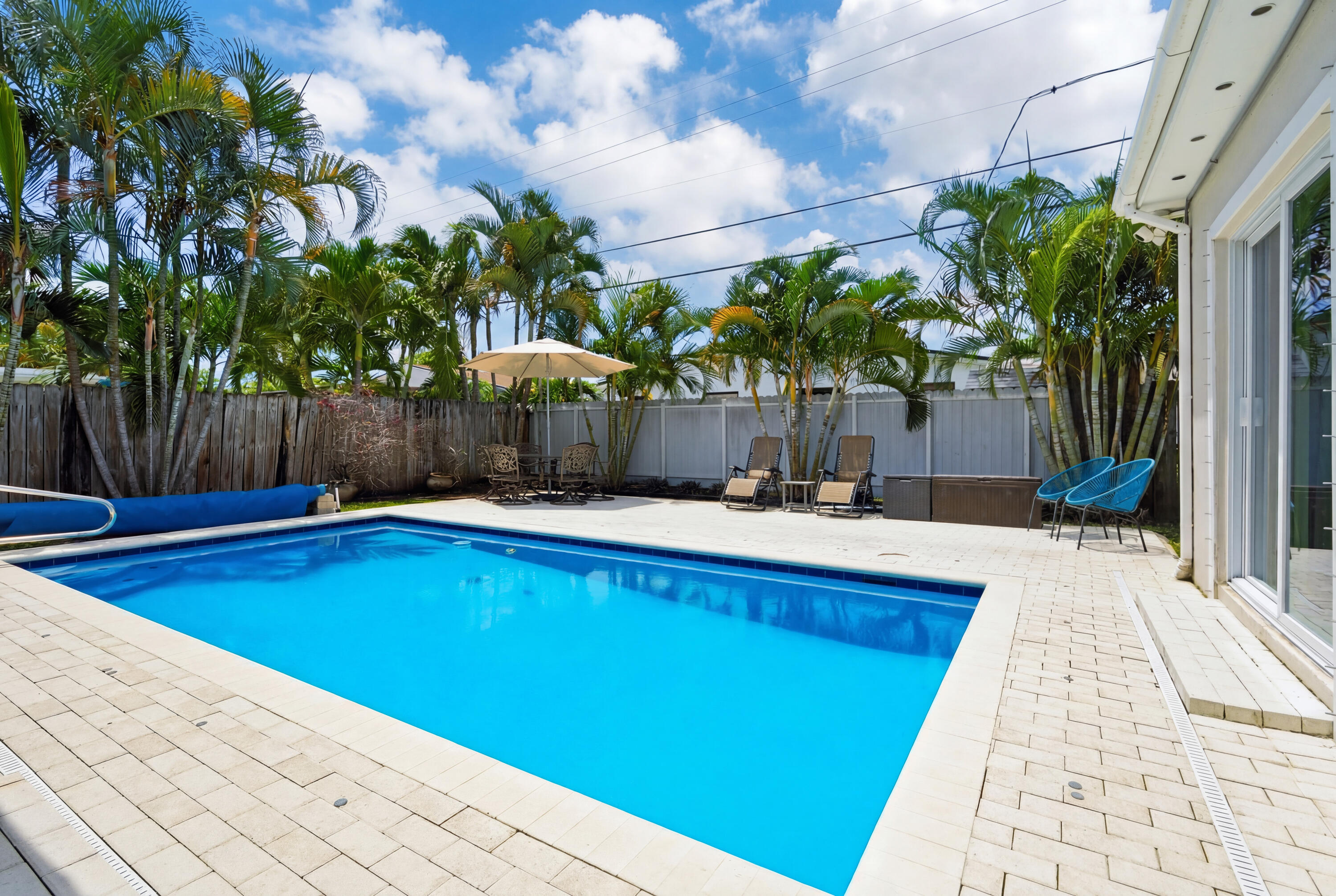 Fabulous 3 bedroom 2 bath home with flex room just off the main bedroom, leading to the pool and patio area. Perfect for gym, meditation, office, library or child's play area. So many options here. The pool was redone as well as the surrounding patio area making a luxurious tropical paradise to relax and enjoy.  The back yard is completely fenced to keep pets and children in, and everything else out! There is also a child fence for the pool which conveys with the home should you have children and pets to keep safe and comfortable.  These wonderful owners have done so many great things to this home. Beautiful light colored vinyl flooring was installed throughout, giving a light open feel to the home. Impact windows, new blinds and so much more.  You really need to come and see for yourself! Sellers have tented the home in October of 2022.  In 2023 they had all the Air conditioning ducts and vents cleaned as well as the AC unit while also installing an anti microbial UV light on the system. Most importantly they have installed impact windows and 2 sliders leading to the pool that are also impact as well. The two newer sliding doors that are nonimpact have hurricane shutters in case it is needed. This home offers a split floorplan with main bedroom on one side and the two other bedrooms on the other. The main bedroom offers an ensuite bathroom and walk in closet. The main bathroom as well as the guest bathroom offer bath tubs as well as showers. Several large screen TV sets are mounted in the home, to include one outside in the amazing pool area, and all will convey with the home. Central heat and air throughout the home, however sellers added a mini split in the 3rd bedroom because seller works out of this room and prefers it extra cold! The swimming  pool is nice and large and is heated only by nature with direct sunlight overhead. There is also a solar cover to keep the water warm when not in use. Wonderful large pantry/laundry/storage room is located just off the kitchen area keeping groceries and all things necessary close and handy. This home is neat and clean, charming and spacious, and ready to welcome new owners  as these sellers move west to be closer to family.  The view of the large swimming pool will knock you off your feet as you enter the home and offers many views throughout the different rooms. This home is definitely one that you should not miss. So much love and thought went into it, along with attention to detail, making it the perfect place to live and play. Concrete block construction giving peace of mind that your new home is sturdy and solid. Ample parking and a quiet street perfect for families, couples or retirees as well.  Whatever your lifestyle, 250 NE 57th Street is the home you will want to call yours. Come visit today and see the potential for your next new home!