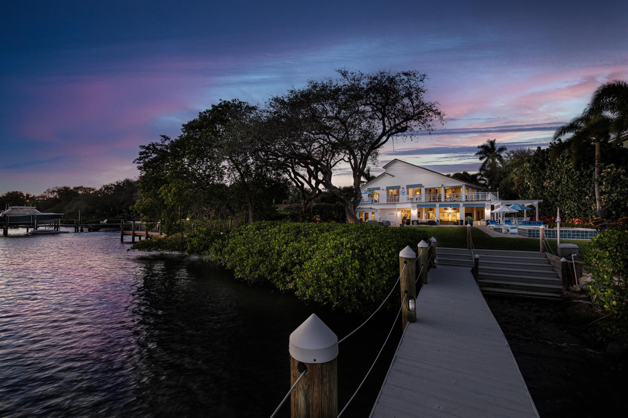 Seize the rare opportunity to own one of the most coveted properties on Jupiter's prestigious Pennock Point, featuring 117 feet of direct river frontage. This extraordinary 5-bedroom, 5-bath custom estate offers the quintessential Florida lifestyle, nestled on nearly an acre of lush, tropical landscaping. Enjoy breathtaking wide-water vistas of the iconic Jupiter Lighthouse, and premium southern exposure—an idyllic blend of privacy and natural beauty. Spanning 4,700+ sq. ft. of refined living space and over 2,400 sq. ft. of resort-style outdoor entertaining, this meticulously renovated residence is equipped with top-tier Wolf & Viking kitchen appliances, a full-house generator, and impact-resistant windows and doors. A boater's paradise with direct, unparalleled access to our waterways. This exceptional estate is a showcase of modern sophistication and luxury. Home upgrades include a state-of-the-art $35k IT and Sonos system, a salt-chlorination pool pump with Jandy AquaLink technology, and marine-grade decking for jet skisfurther elevating the living experience. Every detail has been meticulously designed to offer the perfect blend of modern convenience.

Step outside to your expansive outdoor oasis, where a teak-wrapped deck and a spacious upstairs covered balcony with a screened-in area offer year-round comfort. Whether you're relaxing by the resort-style pool beneath a new pergola or entertaining guests in the generous covered lanai with a newly built summer kitchen, every space is designed for seamless enjoyment. The summer kitchen is equipped with piped propane and water, along with an extended DCS grill, perfect for effortless outdoor cooking and entertaining.

A boater's dream, this property boasts a private, oversized dock with panoramic river views, two boat lifts (16k lb. & 10k lb.), and marine-grade decking for jet skisproviding direct access to some of the most sought-after waters in South Florida.

Inside, the first floor offers seamless living with an open kitchen and pantry, casual dining spaces, a cozy family nook, office, two spacious bedrooms, and two full bathrooms. Upstairs, the luxurious master suite opens to the covered balcony, while two additional bedrooms, three full baths, and an expansive great room with soaring ceilings, natural light, and a stunning propane fireplace overlooking the river await.

Live the Florida dream in this unparalleled waterfront estate, where no detail has been overlooked and every convenience has been considered. With miles of pristine blue water, world-class golf & boating, top-rated restaurants, shopping, and more just minutes away, this is the best of Jupiter living. Schedule your private showing today.
