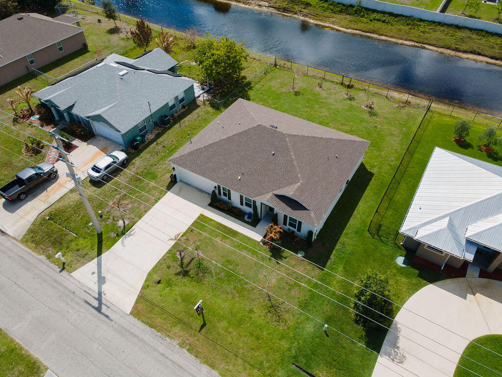 Welcome to your dream home in the heart of Port Saint Lucie! Built in 2023, this beautifully crafted 4-bedroom, 2-bath residence offers modern design, energy efficiency, and peace of mind. Enjoy true smart living with full home automation—control lights, doors, A/C, and garage door with ease using Amazon Alexa or Google Nest at the push of a button. Situated on a spacious 10,018 sq ft waterfront lot, relax with serene backyard views. No HOA means no monthly fees and more freedom. Conveniently located near shopping, dining, and major highways—this is the perfect blend of comfort, location, and value!