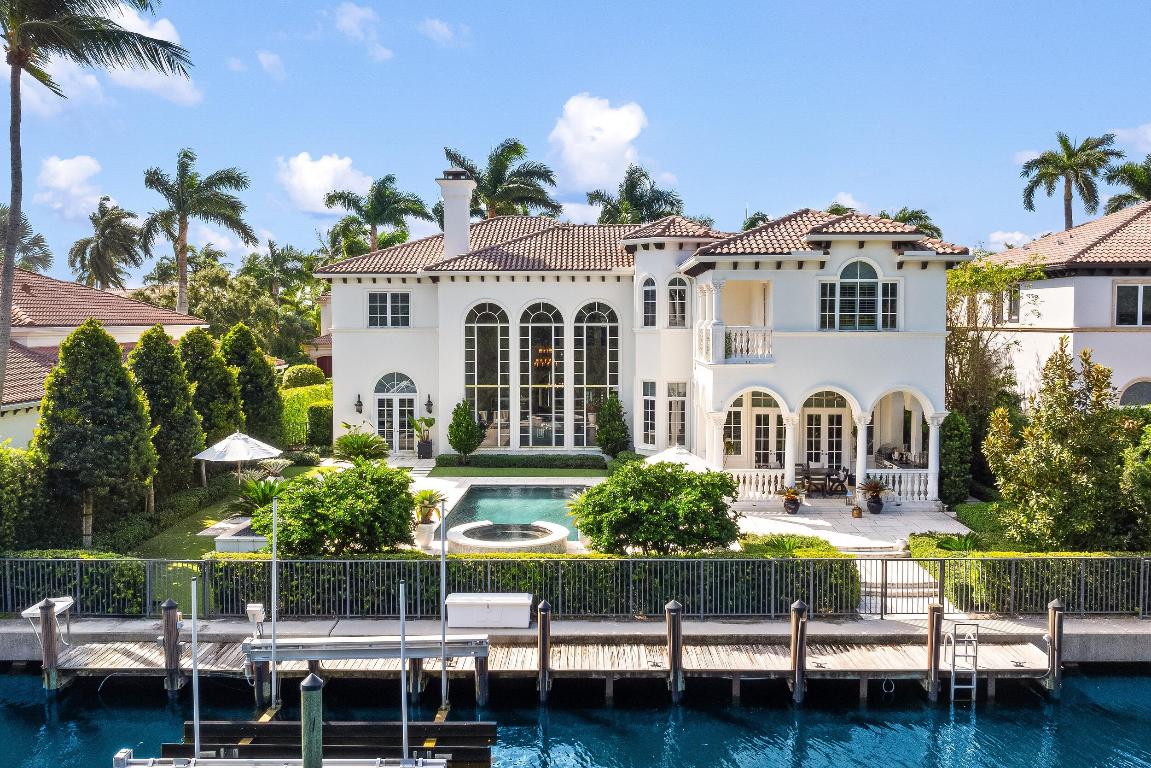 Beautiful waterfront estate with 5BR/5.2BA, library, and 90' of Intracoastal frontage. Phenomenal deep water dock with no fixed bridges. Fantastic floor plan perfectly proportioned over 8,400+/- square feet.  Gorgeous double-height living room with fireplace. Chef's kitchen with oversized island and breakfast bar opens to family room. Oversized Primary Suite with balcony features beautiful water views. Highlights include formal dining room, elevator, and 3 car garage. Stunning loggia with built-in summer kitchen is perfect for entertaining.  Fabulous backyard with resort-style waterfront pool and spa.