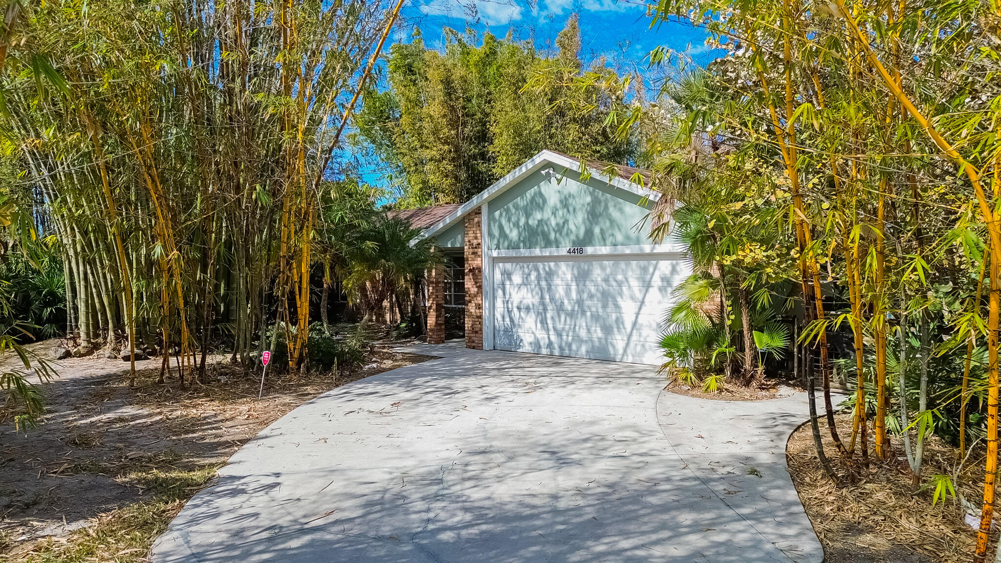 Discover your private tropical oasis in this move in ready 3/2/2  pool home! Perfectly situated on a spacious corner lot, the property is enveloped by mature, tall bamboo for ultimate natural privacy. The modern interior features tile flooring throughout and an updated kitchen complete with elegant granite countertops and sleek stainless steel appliances. Step outside to your personal retreat: a covered lanai and screened-in pool area designed for entertaining, featuring a convenient outdoor shower. With a 2-car garage, a newer roof (2022), and no HOA fees, this move-in-ready gem offers the perfect blend of secluded Florida living and contemporary comfort.