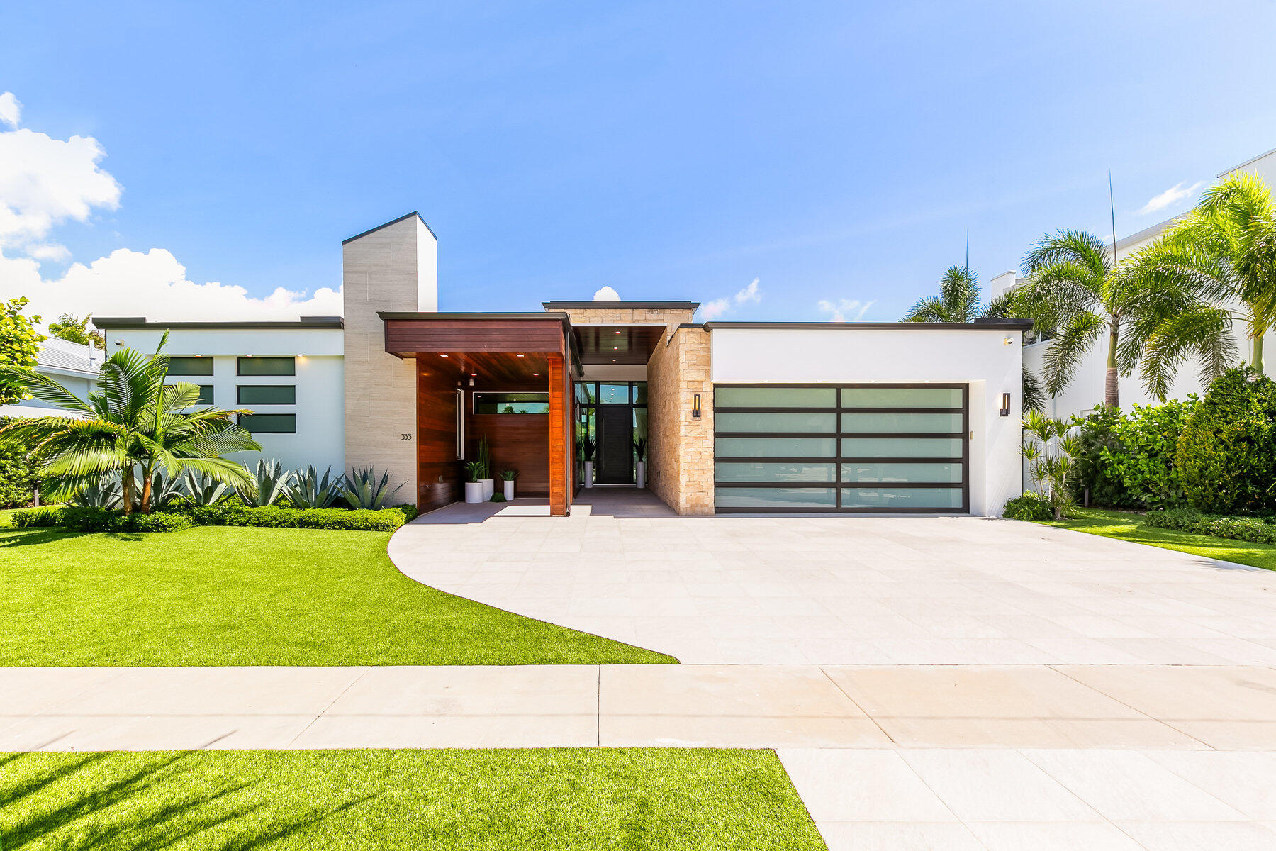 Welcome to an extraordinary single-story residence nestled on a sprawling oversized lot of 13,582 square feet in the coveted Golden Triangle of East Boca Raton. This exceptional home, crafted by NuVision Developments in 2021, features 5 bedrooms, 5 ensuite bathrooms, and two half baths, highlighted by a primary wing that overlooks the saltwater pool and summer kitchen.
The interior showcases a beautifully designed open concept layout with high ceilings and 30'' x 60'' matte Italian porcelain tile flooring. Flooded with natural light, the sun-drenched great room, kitchen, and dining area boast expansive glass sliders that seamlessly blend indoor and outdoor living, offering panoramic views of the resort-style pool, patio, summer kitchen, and cabana bath. The outdoor space is a tropical oasis, enhanced by an expansive yard including a putting green.
The gourmet kitchen is outfitted with top-of-the-line appliances, including a Wolf dual fuel range, Subzero 48" fridge, supplemental induction cooktop, speed oven, and built-in coffee system. A generous walk-in pantry complements the kitchen, ideal for culinary enthusiasts and entertainers alike. Additional features include automated blinds in the main area and primary bedroom, a striking wine display, and a Savant smart home system.
Conveniently located just steps from the shops and dining of Mizner Park, and within a picturesque stroll to the intracoastal and beach, this home offers unparalleled luxury in the heart of Boca Raton. Perfect for buyers seeking an exquisite blend of sophistication and proximity to the vibrant lifestyle of this most highly sought-after community.