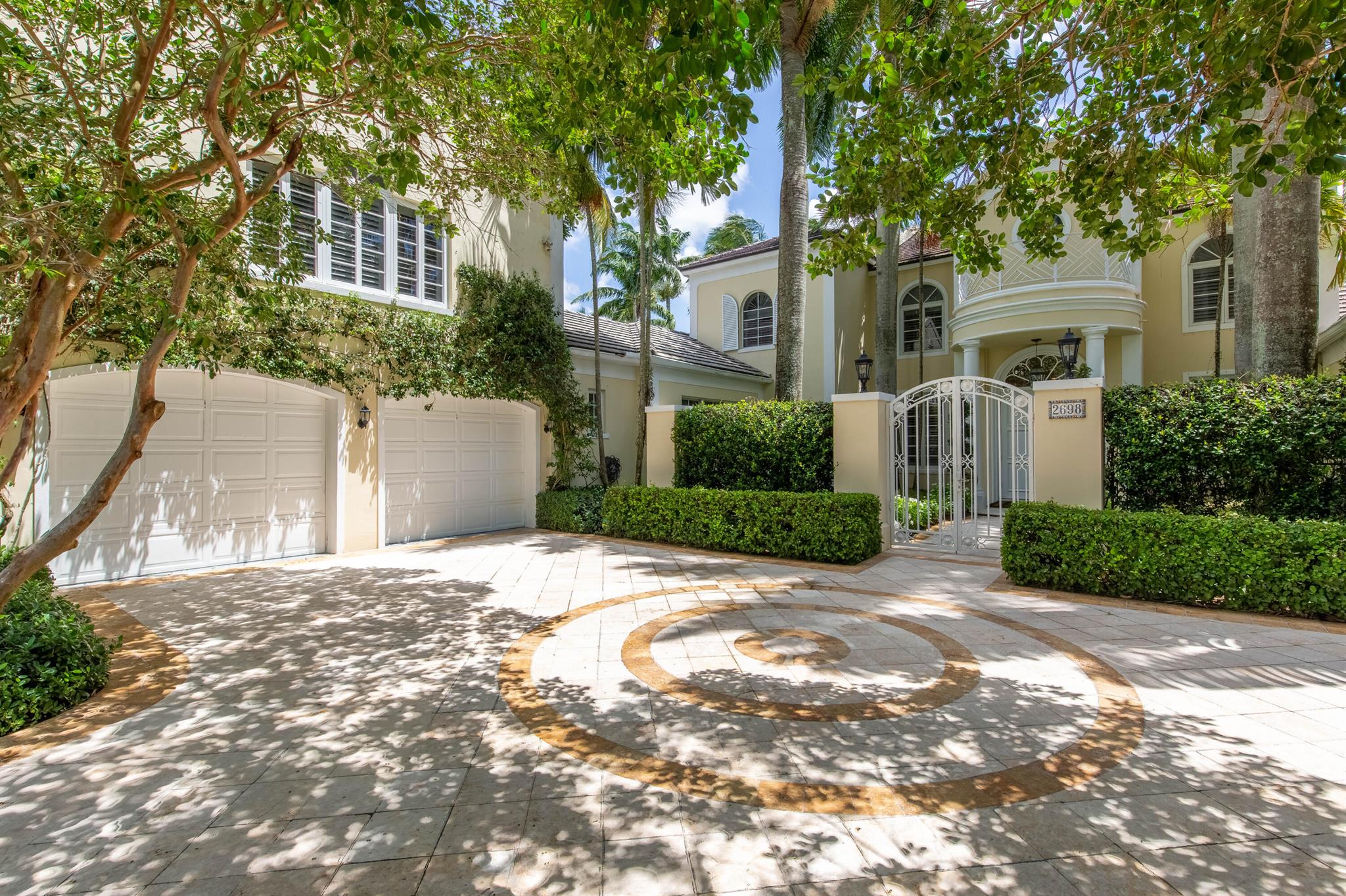 Located in the prestigious neighborhood of Kensington within the private gates of the Palm Beach Polo Club, this elegant estate is situated on over half an acre and boasts 8,033 sq ft of living space with 6 bedrooms, 7 full and 2 half bathrooms, a 3-car garage, charming courtyard entry, a resort-style outdoor living area, pool and spa. The custom floor plan is ideally configured for family and guests, featuring a poolside detached cabana suite, guest living quarters above the garage with private entry, and a second floor oversized guest suite with a sitting room. Encompassing the main floor is a large formal living room, formal dining room, den/family room, a generously sized guest suite with a full bath and walk-in closet, powder room, laundry room with dual washer/dryers, and the recently updated kitchen featuring Wolfe and Miele appliances, custom white cabinetry, and a wet bar area with a wine chiller. The east wing of the home hosts the lavish owner's suite, equipped with his and hers bathrooms and walk-in closets, a large sitting room/office, and access to both the pool deck and a separate secluded patio area. Up the main staircase you'll find two guest suites, each with full baths and entry onto the expansive covered balcony which offers stunning tropical views of the backyard. The second guest room boasts a large attached living room with lofty ceilings, a fireplace and a secondary full bathroom. In the west wing, a private hallway leads you to a service door to a quaint private patio area and stairs to the above-garage suite which includes a large loft/living area. The cabana guest house is the perfect poolside retreat, offering a kitchenette, living room, full bath and a walk-in closet. Just outside, there is another half bath as well as the covered summer kitchen. Extending down the length of the main house, the expansive covered patio hosts multiple sitting and dining areas, a perfect area to take in the beautiful scenery and blissful atmosphere.