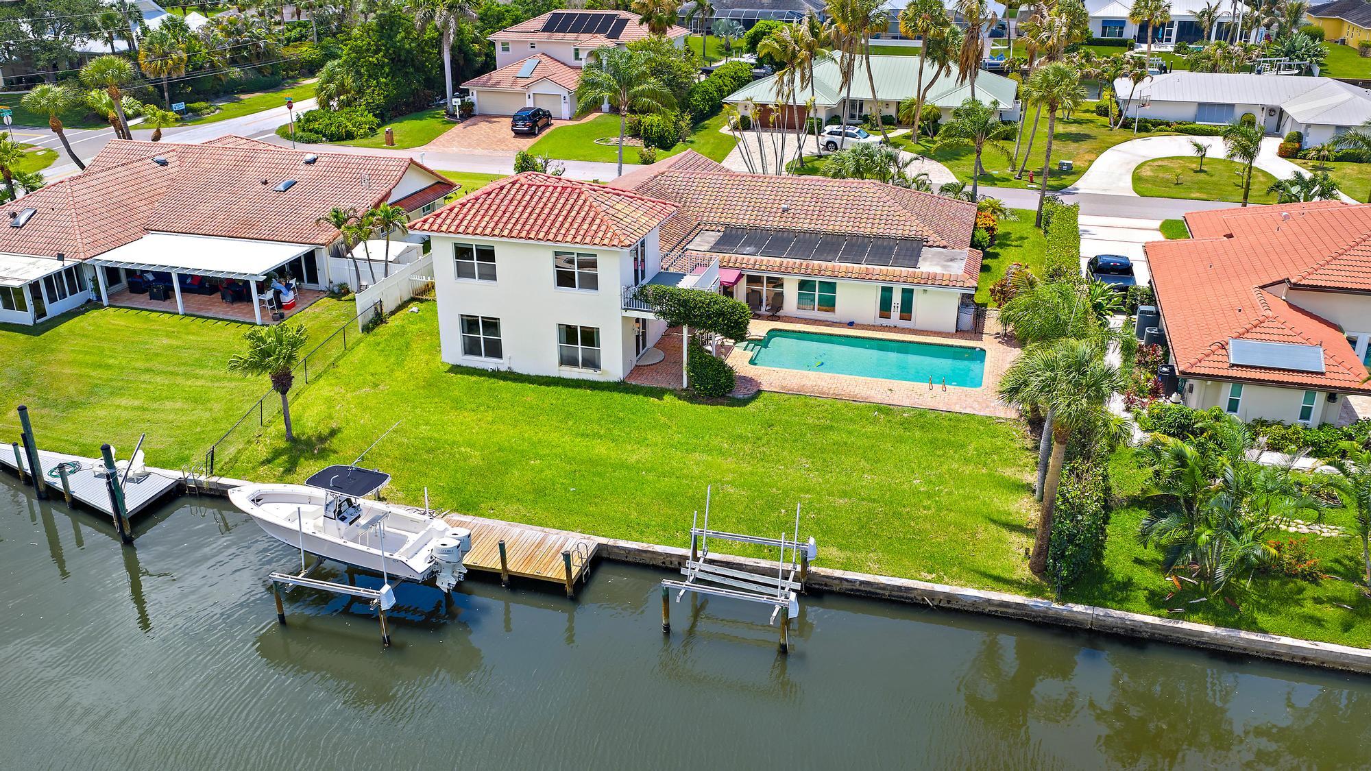 If you've been searching for the ultimate waterfront lifestyle, you've just found it! NO HOA, NO FIXED BRIDGES! This 5 bedroom 4 bathroom house is located on a deep 100-foot-wide canal with direct access to both Jupiter and Stuart Inlets. As you enter, you'll notice the stunning newly remodeled kitchen, thoughtfully renovated in 2025 designed for gathering. Whether you're hosting friends after a day at the sandbar or enjoying a quiet family dinner, the open layout and oversized island creates the perfect space to connect. Two beautifully updated bathrooms, also renovated in 2025. Step outside to an oversized pool overlooking the canal, with two boat lifts. Minutes from pristine beaches, golf, dining, and everything Hobe Sound has to offer!