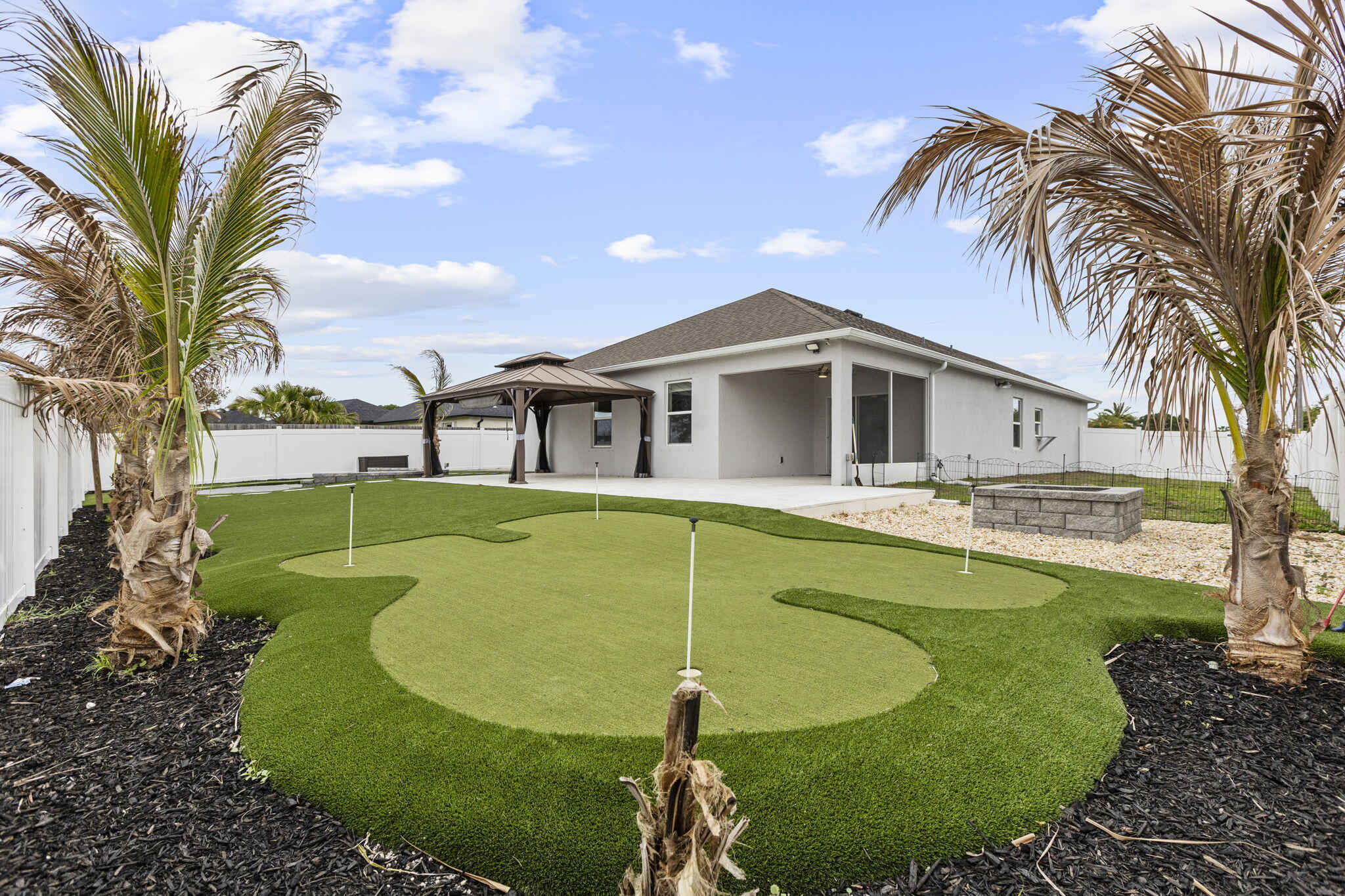 $320k @ 2.99% transferable loan!!!!! Step into your own private paradise with this upgraded 4/2/2 home featuring exceptional indoor-outdoor living on a canal. The exterior showcases a custom golf putting green with travertine tile and low-maintenance turf, a massive fire pit area, and even a mini basketball court. There is a carport perfect for all of the rec. toys, plus a spacious driveway that comfortably accommodates up to 6 cars. Inside, the home boasts of modern upgrades throughout, including brand-new appliances, luxury lighting, and upgraded tile. The kitchen is a standout feature, extra cabinetry, a custom backsplash, a coffee bar, and an island. The primary suite is designed with a tray ceiling, custom closet system and a master bath with a separate soaking tub.