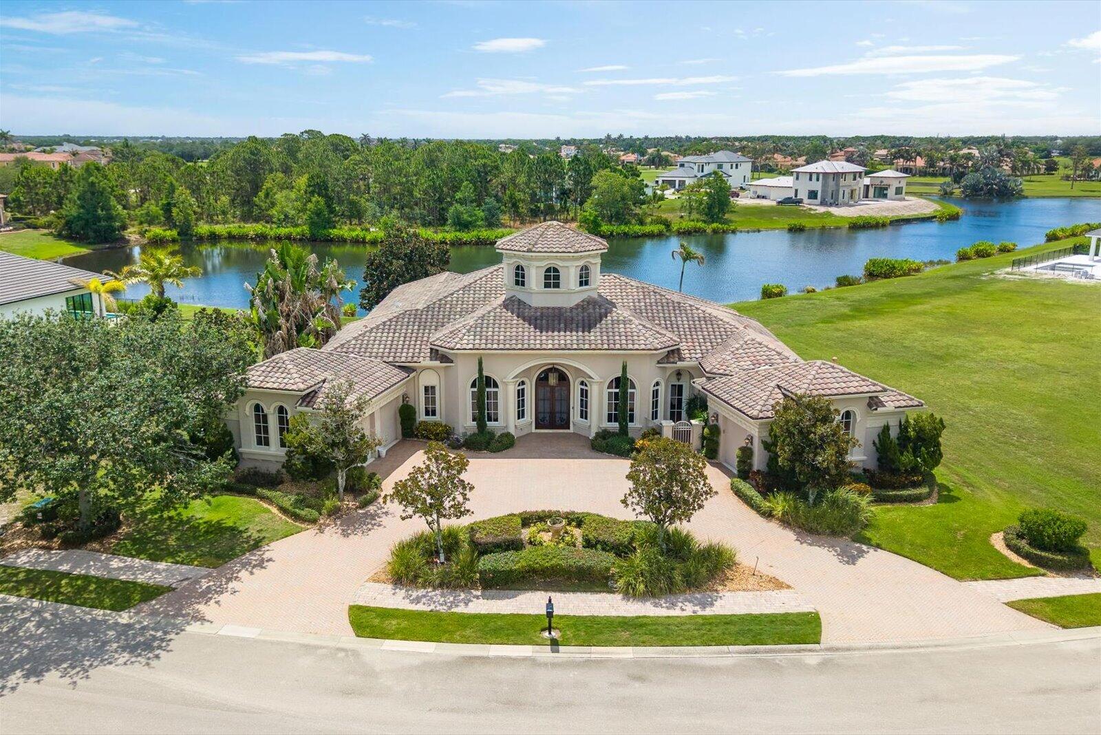 This exceptional Lakefront Pool Home is in Tesoro Golf Club, where sophisticated living meets a serene suburban lifestyle. Membership in the club is optional. The single-story home offers 4,118 square feet of A/C living space, featuring spacious bedrooms & 4.5 bathrooms designed for comfort & convenience. The thoughtful layout features a private garden visible from the Living, Dining & Bedroom 2. The Main bedroom has a vestibule entry, 2 large closets, a private screened porch, & 2 well-appointed baths. The kitchen & family room have high ceilings with oversized windows that look out onto the lake. The Kitchen features natural gas cooking, a bar, a work island, and a walk-in pantry. The Lania overlooks the pool & has a built-in BBQ grill, large seating area & convenient power screens.