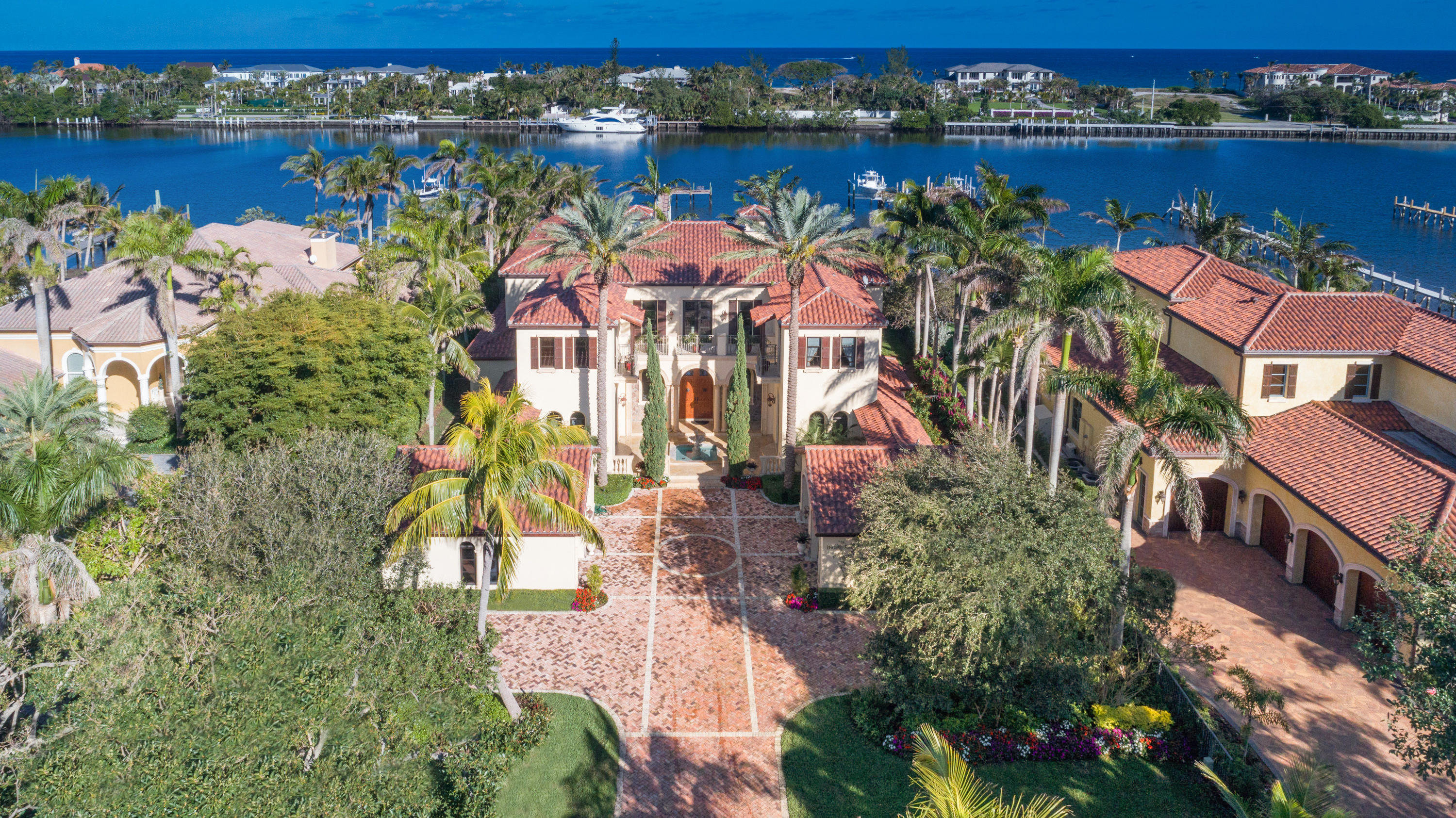 Privacy, charm and distinction blend seamlessly in this custom-designed and built half acre waterfront residence.  Located on a secluded street on the east side of Hypoluxo Island, an impressive motor court flanked with double two car garages leads to a stately two story Mediterranean home, with open terraces and courtyard fountain entry. The foyer opens to a living room with magnificent water views, and a dramatic, winding staircase leads to an open second floor with four bedroom suites, including the master bedroom with twin closets and bathroom areas.  Home has a custom built aquarium, a clubroom, a library loft, a spa/exercise room (also a sixth bedroom), a courtyard dining room, and a spacious kitchen that serves an eating area and family room.  A covered patio with a barbecue entertainment bar and an exterior fireplace lead to a separate poolside guest suite.  An open pool with stone patio deck and infinity spa bask in southeast ocean breezes and sunshine, and a deep yard of mature tropical trees, leading to a long walking dock which reaches into the waterway and accesses wave runners and the potential for multiple sized boats.