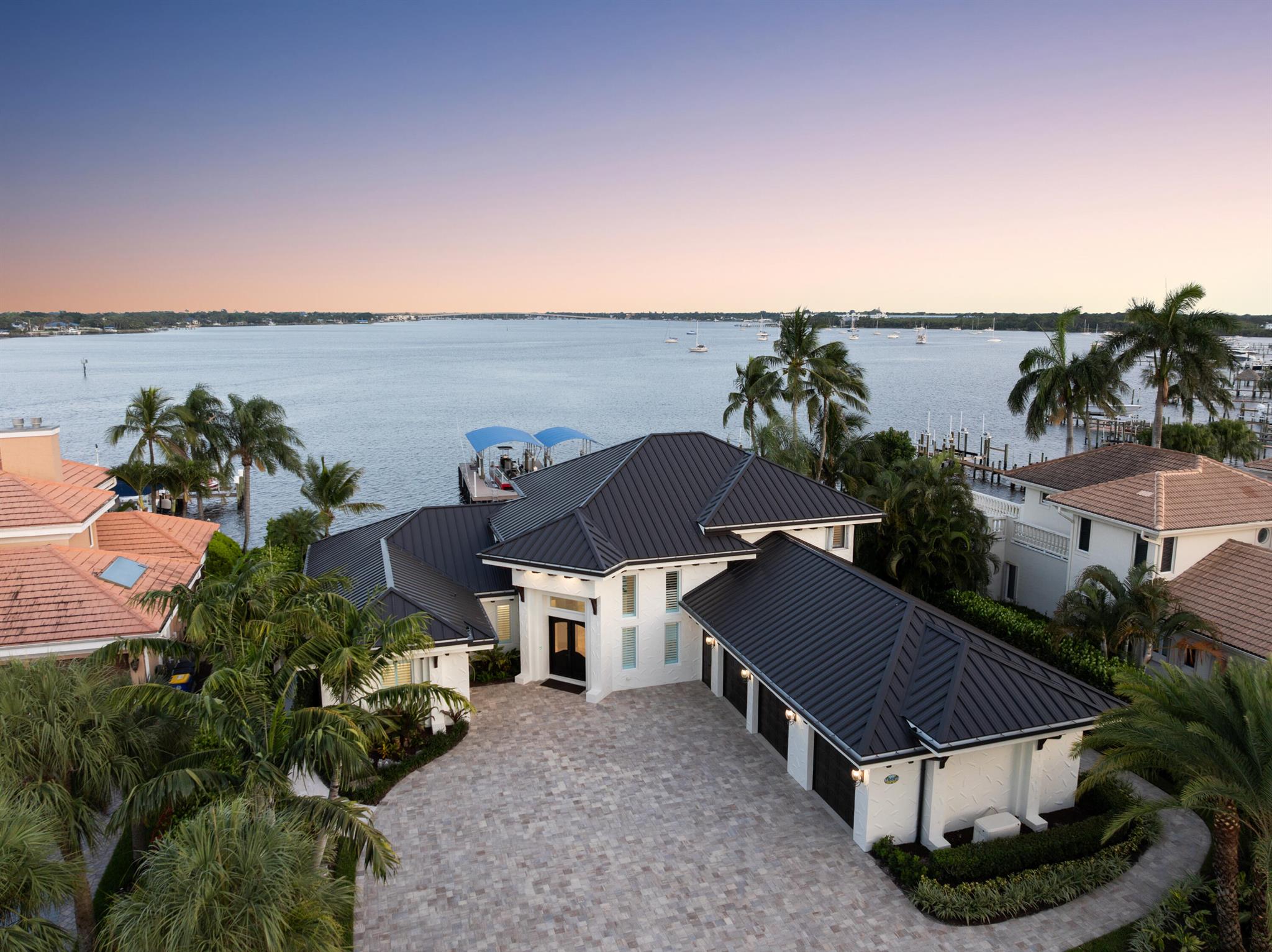 Located in the private, gated enclave of Bay Pointe, this reimagined waterfront estate offers 100' of wide river views, eastern exposure, and deep water dockage for a 95' yacht. Features include a new standing seam metal roof, PGT impact glass, marble and refinished wood flooring, and re-stuccoed exterior. The chef's kitchen has quartzite counters, custom cabinetry, Bertazzoni/Bosch appliances, Sub-Zero fridge, copper fixtures, and swing-out barstools. The primary suite offers dual walk-ins, spa bath with freestanding tub, walk-in shower, and private den with water views. Outside, enjoy a saltwater pool with marble pavers, in-pool stools, fountains, turf, putting green, and firepit. Dock includes synthetic decking, 24K/16K lifts, mooring whips, power/water pedestals