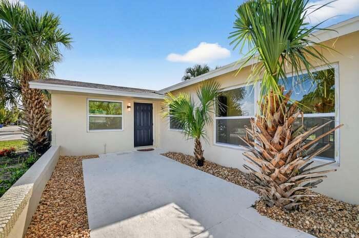 Beautifully renovated 3BR/2BA home on a landscaped corner lot.  This move-in-ready gem blends classic charm with modern luxury, featuring an open living area, fresh tile floors, and a sun-filled, climate-controlled Florida room with a rustic tongue-and-groove ceiling. The designer kitchen boasts custom white oak cabinetry, quartz countertops, and a premium suite of LG smart appliances (including an InstaView fridge). Relax in the primary suite with a walk-in closet and a fully upgraded ensuite bath. High-end finishes continue in the guest bath with a Delta shower system and Kohler fixtures. Notable upgrades include a new 200-amp electrical panel, a smart thermostat, a new Rheem water heater, a new LG washer/dryer, and a timed sprinklers.  Near Singer Island.  The perfect South FL. retreat!