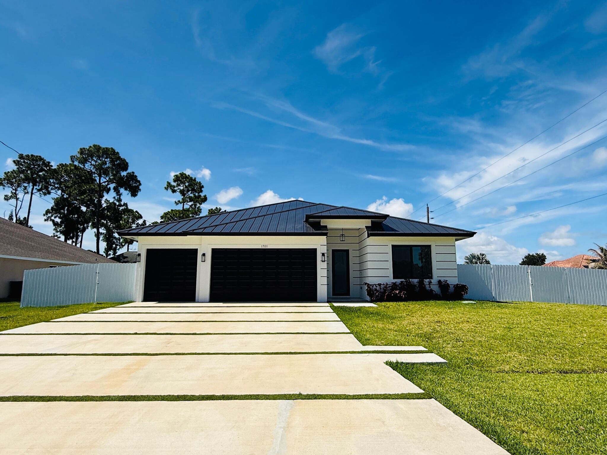 Immaculate 2025 construction, gently lived in for only six months and truly move-in ready! This beautifully maintained 4-bedroom, 3-bath home offers 2,239 sq. ft. of thoughtfully designed living space and an oversized 3-car garage. Designed for both style and comfort, it features a modern open-concept kitchen with quartz countertops, double ovens, premium finishes, and stunning marble-style flooring. Bright, airy interiors invite natural light throughout, while hurricane-impact windows provide added peace of mind. Situated on an oversized corner lot, the custom concrete driveway enhances curb appeal. The fully fenced backyard features a brand-new white vinyl fence and ample space for entertaining, pets, or relaxing. Meticulously cared for and in like-new condition, this home is a rare  opportunity. Schedule your private showing today!