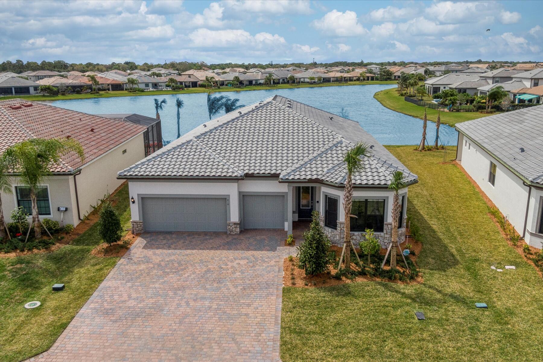 Welcome to a Florida dream in the beautiful master planned community of Veranda Gardens only 15 minutes fromdowntown Stuart and the water! This home is amazingly equipped with over $120,000 in builder upgrades plus $60,000 in technology upgrades like custom automated shades, custom sound system and lighting. This is the largest floorplan in a one story home and a true 3 car garage and a water view! High volume ceilings, smooth finish walls, 3 pane disappearing sliders and extra lighting throughout. The gourmet kitchen has a gas stove cooktop, stainless steel appliances, custom cabinets and full tile backsplash with an oversized quartz island and plenty of storage with a walk-in pantry. All this within a gated community with a brand new state of the art gym, resort style pool and amenities.