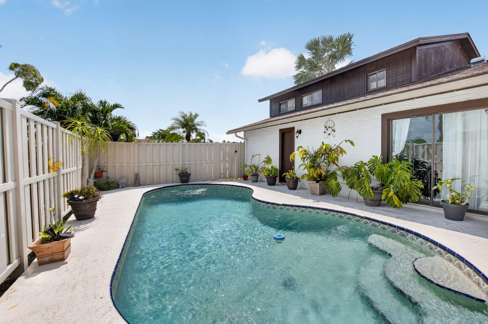 Rare opportunity to own a private pool home in Boca Gardens. This move-in ready residence has been thoughtfully updated and offers a desirable combination of indoor comfort and outdoor living. The remodeled kitchen features stainless steel appliances, updated cabinetry, and ample workspace. New waterproof luxury vinyl plank flooring throughout the main living areas on the first floor creates a fresh, contemporary feel, while the renovated primary bathroom showcases updated fixtures and finishes. A newer air-conditioning system provides added peace of mind. The spacious layout is filled with natural light and flows seamlessly to the private outdoor retreat. Enjoy your own screened private pool area, offering space for relaxation, entertaining, outdoor dining, or simply enjoying Florid Florida living year-round. The flexible floor plan provides comfortable living spaces and generous room sizes, with thoughtful updates throughout that allow the next owner to move right in and begin enjoying the home immediately. Located within Boca Gardens, residents enjoy access to community amenities including swimming pools, tennis courts, basketball courts, playgrounds, walking paths, and clubhouse facilities. Conveniently situated near shopping, dining, parks, recreational opportunities, and major roadways. Updated kitchen, renovated primary bath, new waterproof luxury vinyl plank flooring, stainless steel appliances, a newer air-conditioning system, and a private pool make this a unique opportunity within the community.  enhanced by an HOA that covers roof maintenance and replacement, exterior maintenance, and cable. Boca Gardens residents enjoy an impressive collection of amenities, including three community pools, tennis and pickleball courts, basketball courts, a fitness center, clubhouse, playgrounds, and scenic walking paths amid lush landscaping. Conveniently located near top-rated schools, premier shopping, dining, parks, and major highways, this residence offers an exceptional Boca Raton lifestyle. Private pool homes with this level of privacy, thoughtful updates, and resort-style amenities are seldom available. Experience one of Boca Gardens' most desirable offerings.