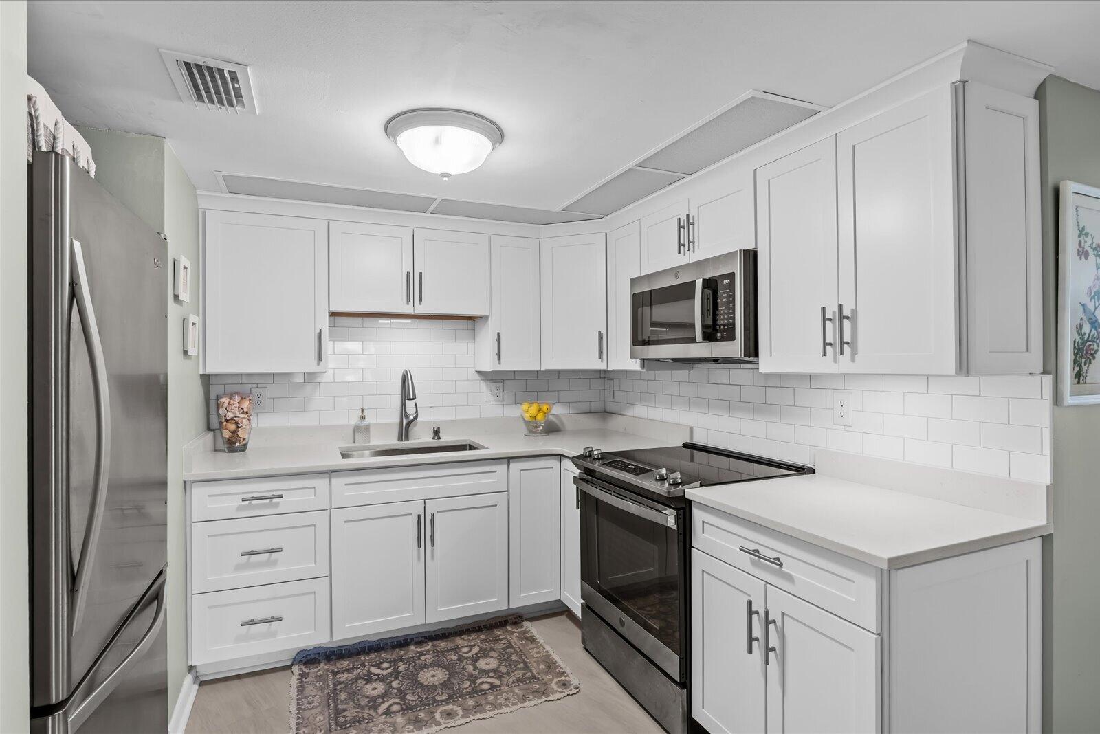 Discover one of Jensen Beach's most compelling opportunities an exceptionally renovated first-floor residence offering effortless Florida living with immediate occupancy available. Thoughtfully designed and beautifully updated, this stunning model presents the rare combination of style, convenience, and move-in-ready ease that today's buyers are searching for. The residence may be purchased turn-key, allowing for a seamless transition into your new lifestyle (furniture negotiable through seller only). Pet friendly and all ages welcome...ideally positioned on the first floor, this home offers comfort and accessibility rarely found at this price point.  Extensively enhanced in 2023 with a remarkable list of improvements including luxury vinyl plank flooring throughout, new air ducts, new air conditioning system, water heater, washer and dryer, refrigerator, microwave, stove, kitchen cabinetry, elegant quartz countertops, oversized stainless steel sink, updated vanities and faucets, modern shower enclosures, ceiling fans, toilets, closet doors, removal of popcorn ceilings, new outlets, fresh interior paint throughout, and accordion shutters for added peace of mind. The result is a residence that feels fresh, refined, and thoughtfully reimagined from top to bottom. Opportunities offering this level of renovation, immediate availability, and turnkey convenience in Jensen Beach do not remain available for long. Schedule your private showing today and experience the lifestyle for yourself.