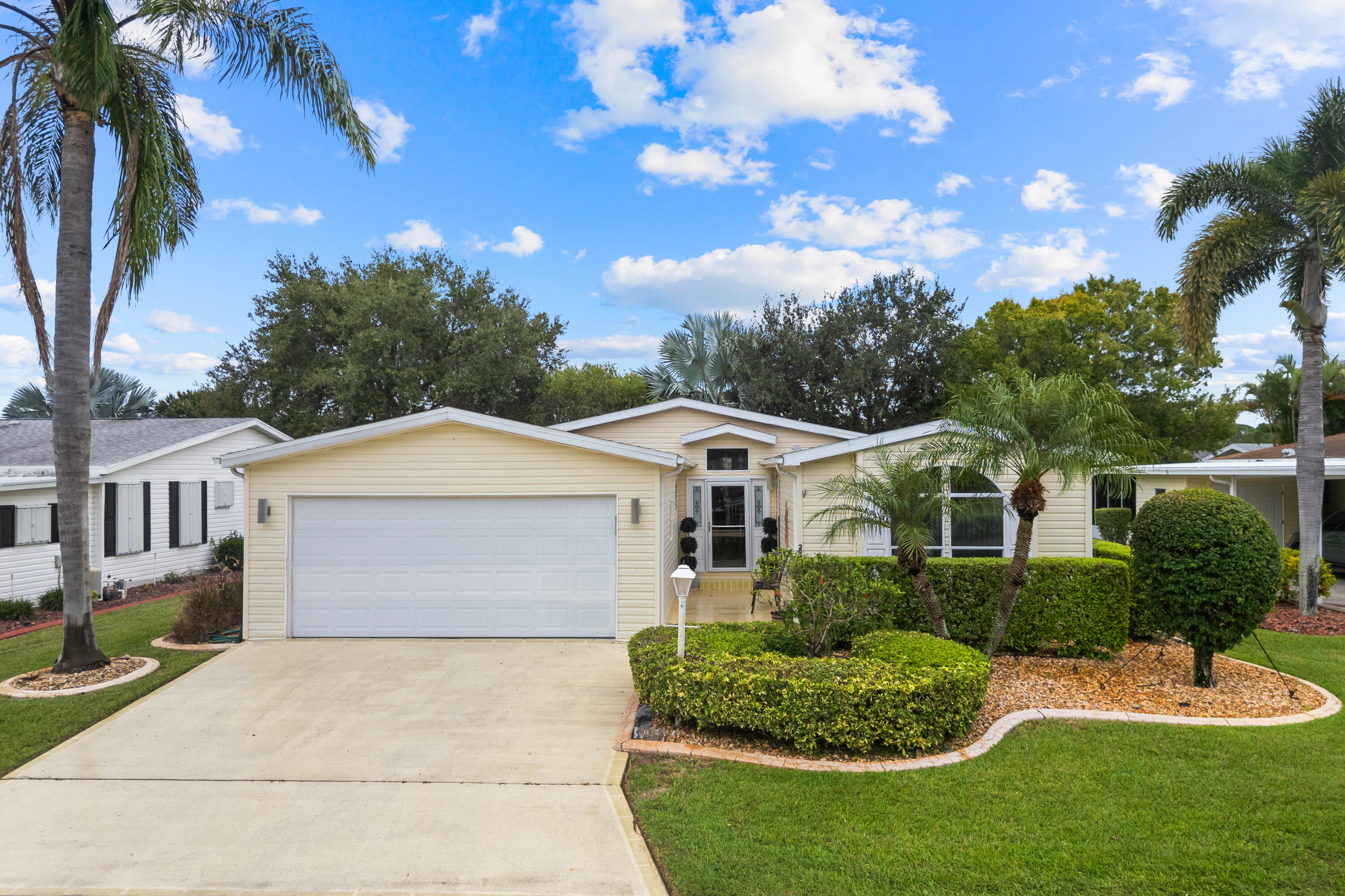 WOW!  HUGE PRICE DROP!!!  This charming split floor plan 2 car garage home is a keeper!  2 bedrooms, 2 bathroom with a DEN! Perfect open concept floor plan is perfect for entertaining.  Huge extensive lanai along with a mini split AC unit.  This home comes furnished.  Roof & AC 2021 as well as HWH 2023.  THIS HOME IS ON LEASED LAND.