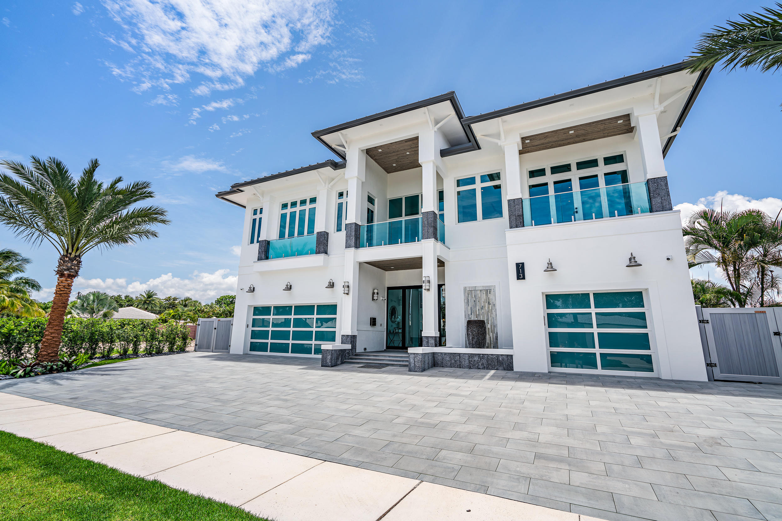 Keeping it natural is the perfect description of this home. This modern yet traditional WATERFRONT home is absolutely breathtaking! This home features an incredible indoor/outdoor feel that allows you to immerse yourself in its undeniable beauty. With 4 gorgeous bedrooms with en suites and a detached guest house serving as a 5th bedroom with a private bathroom, there's a place for you to work, relax, and thrive in unparalleled style. The home's open floor plan with abundant glass windows and doors adds to the contemporary feel. Meanwhile, its wooden features provide the classic touch. It offers a luxurious negative-edge pool that extends from the home into a beautiful yard with open space towards the intracoastal. This one of a kind 6 x 10-foot pivot front door with side lights will have you in complete AWE! T&G ceiling porches, and an alluring water featured front entry invite you inside this "no expense spared" residence. An elegant open custom staircase with shatter proof glass railings draw immediate admiration at the stunning architecture and taste in the home's entryway. The brilliant combination of lustrous wooden 8" beams, Cove crown molding, custom lighting, and glass barn doors boasts of high-class charm. Italian porcelain wood floor tile throughout give the home an impressively elegant and inviting feel. Impact windows with pocket sliders with impeccable custom trim line the walls through this home because safety is of the utmost importance. 

Enjoy 2 stories of well-executed elegance. The first level includes an intimate living room, a formal dining room and a sizable, open concept family room with one of the two sublime indoor gas fireplaces fueled by Navien tankless heaters (with a natural gas supply) delicately cozy and grandly polished for magnificent FLORIDA fall and winter days. The guest bedroom and bathroom are conveniently located on this first level. Glass barn doors welcome you into a sensationally modern kitchen with custom built 
shaker-style cabinets with glass accent doors, glass quartz countertops, and LED under counter lighting, creating an elaborate and enchantingly grand kitchen. Open view to the den and pocket sliding glass doors line the back walls for a view while you cook, host, and enjoy the latest appliances, including a freezer, subzero fridge and stove with a classy custom Viking hood. 

Hop on the elevator to explore upstairs, where you will find tons of natural light and soaring ceilings. Your upstairs area features an open concept office/den, as well as your master suite and two additional bedrooms with en suites and spectacular balconies. 
Joining the upstairs bedrooms is a generous living room equipped with a sliding glass door walkout to a lanai for a perfect intracoastal view. Fresh air and a flawless outlook are just a step away with the spacious lanai, furnished with glass railings that overlook the spectacular pool and canal. Enjoy unique balcony views from every room. 
 
This 7,586 square foot estate (9860 sq. ft. with balconies) resides on a breathtaking canal connected to Intracoastal Waterway. Impact glass balcony railings and a porcelain pool deck lure you outdoors on the daily, showcasing quintessential Southern Florida sunrises you'll want to soak in every morning. Golden accented boat and jet ski lifts (two of each, capable of 14,000 lbs) dawn the exterior, making getting in or on the water quick and easy. The outdoor fun doesn't stop once you get out of the water, though! A divine outdoor summer kitchen with a hood, uniquely eye-catching lighting fixtures, and a screened-in fireplace make hosting an outdoor party, big or small, a must. 
  
The home is fully equipped with a 400-amp service (and a 100 KW Generac generator in case of power outages), a Carrier 4-ton split AC system with Linear Bar Grilles (including a mini split unit for the two-car garage), and natural gas connections for the washer, dryer, fireplaces, Jacuzzi, outdoor kitchen and cabana bath. Enjoy consistent water supply/pressure by 1-1/2" main water line. With efficiency as a priority, the house was built with Icyenne Spiey foam R-20 insulation, a beautiful aluminum standing seam metal roof, and PVC fences and gates. The house is also secured with Lorex Definition (NVR) TWO WAY communication, night vision (a 16-camera system, upgradable up to 44 cameras, and has a 5-year extended warranty that can be expanded for as much memory as needed). The garage and Jacuzzi have PTZ and are compatible with google and amazon. My Q technology is furnished throughout with a garage friendly app and side door with smart locks.  

If you are looking for a one-of-a-kind, custom built, luxury smart home on the water with no fixed bridges then you definitely need to take a look at this masterpiece in person!