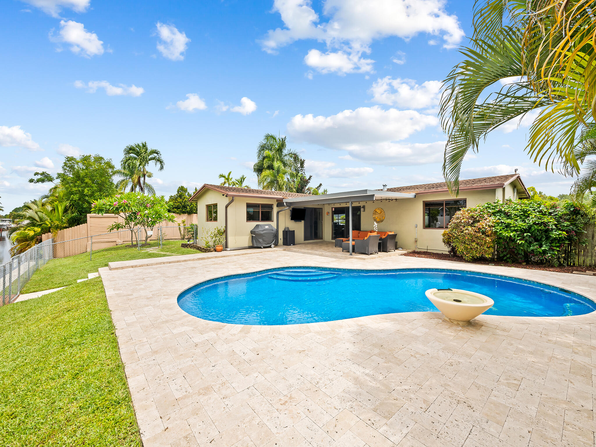 Experience the waterfront lifestyle in the exclusive community of Plantation Isles with no HOA. This meticulously maintained 2-bed, 2-bath home features restored terrazzo flooring and an updated kitchen with stainless appliances, ample storage and extended coffee bar. The sun-splashed open-concept living area offers sprawling views of the waterway and your private saltwater pool. With a split-layout design, the primary suite and second bedroom provide plenty of space, while the home offers room to expand for those looking to grow. Step outside to a grand travertine lanai, perfect for entertaining by the water where your private dock and lift await. Located just a short trip from Plantation Heritage Park and featuring ocean access with only one fixed bridge, this is a true boater's retreat.