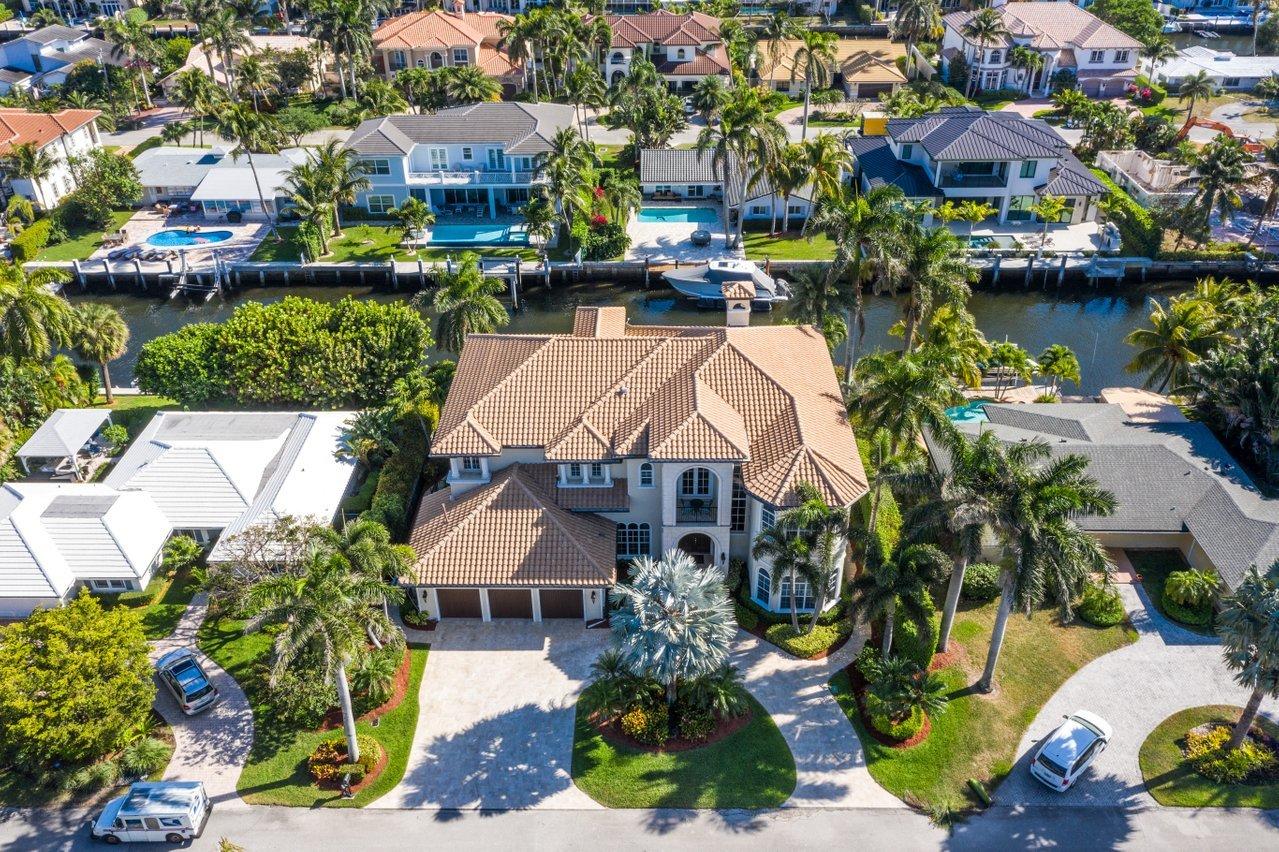 This Spectacular Estate is South Facing on 95 feet of Deepwater, 70-foot dock with 6458 sq. ft. of interior space, 6 spacious ensuite bedrooms, 6.5 baths plus 3rd floor Theatre Room & elevator. Entertain in Paradise by the freeform pool and spa with tranquil waterfall, summer kitchen, spacious lanai, and breathtaking views! This Estate has been meticulously maintained...shows like a model! The gourmet kitchen features 2 refrigerators, 2 freezers, 2 dishwashers, gas burning stove, and opens to Family Room. There are two ensuite bedrooms on first floor and a magnificent master suite on second floor that opens to 2 outdoor terraces overlooking the water. This estate is complete with Impact Windows and Doors, Roof (March 2017), all closets have custom built-ins, Generator 20K, 3 balconies and much, much more!! Walking distance to the Beach! 
Furniture negotiable! Excluded from sale: Jukebox, downstairs South bedroom blue draperies, Bronze Boy & Girl Statue at front entry by fountain.
