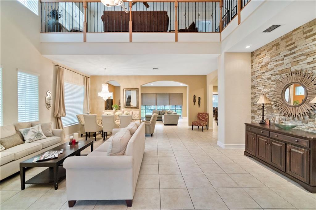 4 Bedrooms 3 Bathrooms plus loft on Private Lot. Home offers rock accent wall at entrance with tile flooring throughout. Formal Living and dining rooms.  Separate family room and breakfast area.  Kitchen has granite counters and wood cabinets, SS appliances and center cooking island. All wood floors upstairs, loft area and balcony off the master bedrooms.  Jacuzzi tub in the master bath with separate shower and double sinks.  Screened in patio area goes out to spacious backyard.  Accordian Hurricane Shutters. Close to Resort Style Clubhouse with Community Pool, Gym, Tennis, Ballroom and much more.