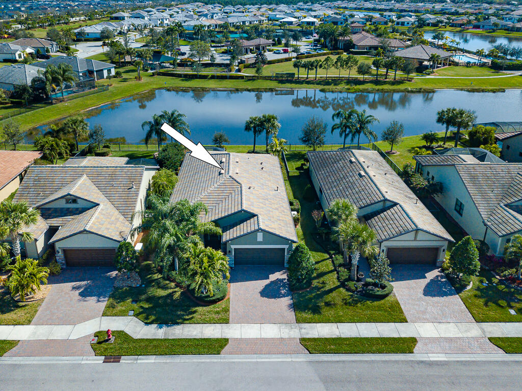 Welcome to Veranda Gardens, where luxury meets convenience. Built in 2016, this picture-perfect home has sparkling lake views, a flexible floor plan & oversized garage that could accommodate a 4th bedroom or extra storage space. This newer construction home offers many benefits such as impact glass, natural gas, whole-house generator, water filtration system, newer a/c, updated light fixtures & designer finishes to elevate the space. The gourmet kitchen boasts quartz countertops, upgraded appliances, an extended island, warm wood cabinetry with w/pullouts, a built-in coffee/wine station, a walk-in pantry & loads of storage. Step onto the oversized screened lanai & unwind in the hot tub while taking in the serene lake views.  Resort-style amenities include a stunning clubhouse w/heated pool & lap pool, barefoot bar, fire pit, fitness, tennis, bocce, pickleball, basketball, dog park & tot lot. Located just minutes from shopping, dining, a boat launch, parks, I-95 & The Florida Turnpike.