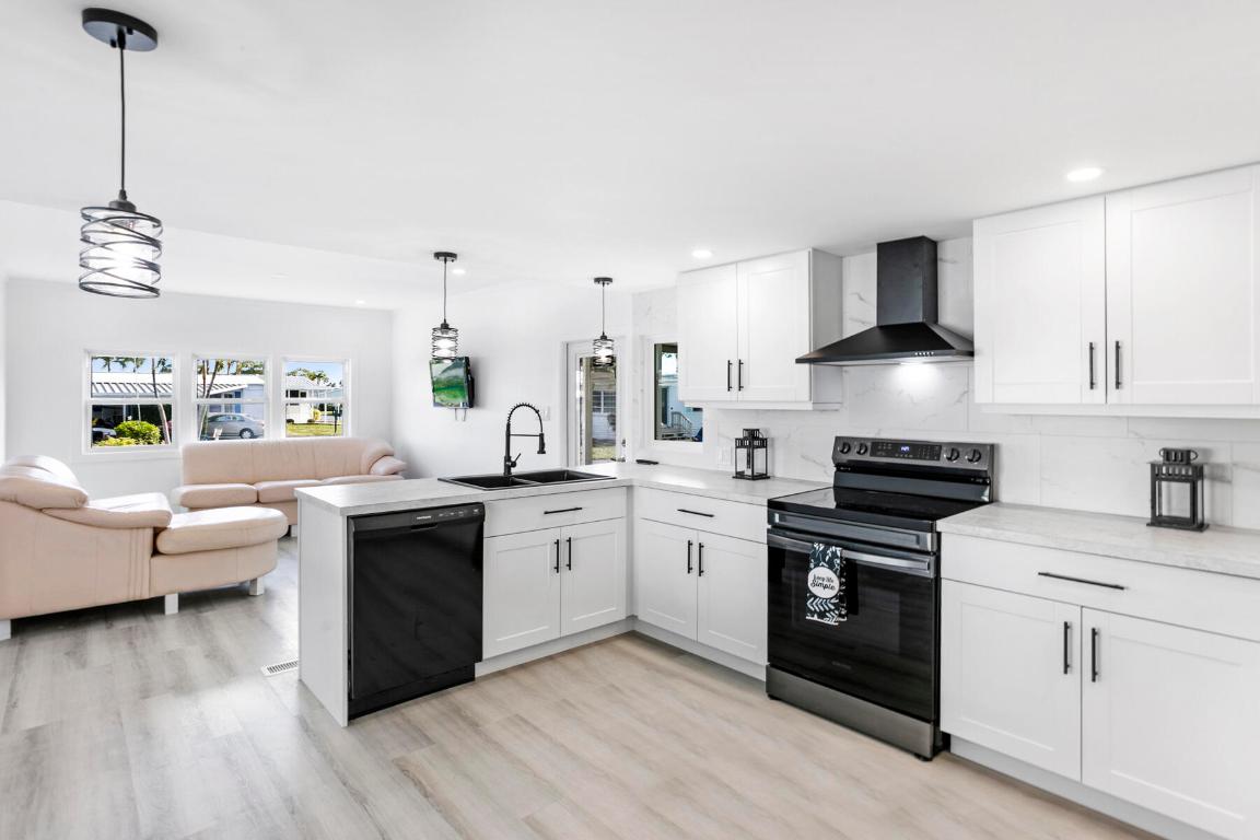 This beautifully remodeled home in a desirable gated community comes with NO land lease and has been upgraded from top to bottom. The kitchen showcases white shaker-style cabinets with sleek black handles, new appliances, abundant counter space, a breakfast bar, and a dining area. The open floor plan flows into a spacious living room that connects to a freshly screened patio, perfect for relaxing or entertaining. Inside, you'll find brand new vinyl flooring, updated drywall, ¾-inch plywood subflooring, fresh insulation, new windows, a tankless water heater, and a washer and dryer conveniently located within the home. The interior has been freshly painted and exterior has new vinyl siding. Additional upgrades include LED lighting, new plumbing, new electrical panel, new interior and exterior doors, and a freshly sealed roof. Just steps away from the clubhouse, residents can enjoy two heated pools, pickleball, shuffleboard, billiards, a library, and a vibrant social calendar. With a low monthly fee of only $250 covering internet, water, sewer, 24/7 manned gate security, on-site management, and all amenities, this move-in-ready home is waiting for its new owners.