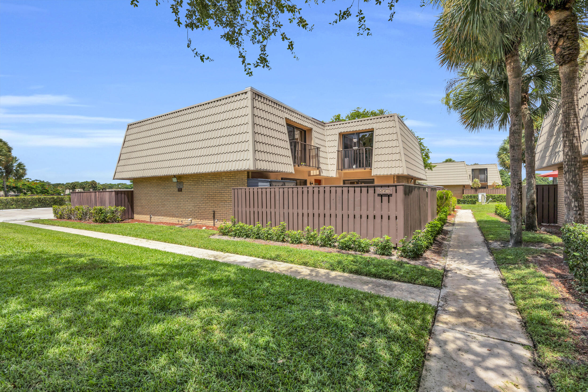 Welcome to this updated townhome in Village of Sandalwood Lakes South. Fresh paint throughout, smooth ceilings, and new LifeProof luxury vinyl flooring on the stairs and second floor give the home a clean, modern feel from the moment you walk in.  The kitchen features granite countertops, a new backsplash, stainless steel appliances, and opens to the living and dining areas. Sliding glass doors lead to a private, fenced patio with an outdoor storage shed—ideal for relaxing, entertaining, or creating your own outdoor space. A half bath is conveniently located on the first floor, while upstairs you'll find two primary bedrooms, each with its own en suite bathroom. Additional updates include impact windows and doors, a newer water heater, keyless entry, and in-unit laundry with new washer and dryer.  Residents of Village of Sandalwood Lakes South enjoy three community pools, playgrounds, tennis and racquetball courts, new pickleball courts,  beach volleyball, open green space, and nearby walking and biking trails. Conveniently located just minutes from Palm Beach International Airport, the Brightline station, downtown West Palm Beach, area beaches, and Palm Beach Outlets.