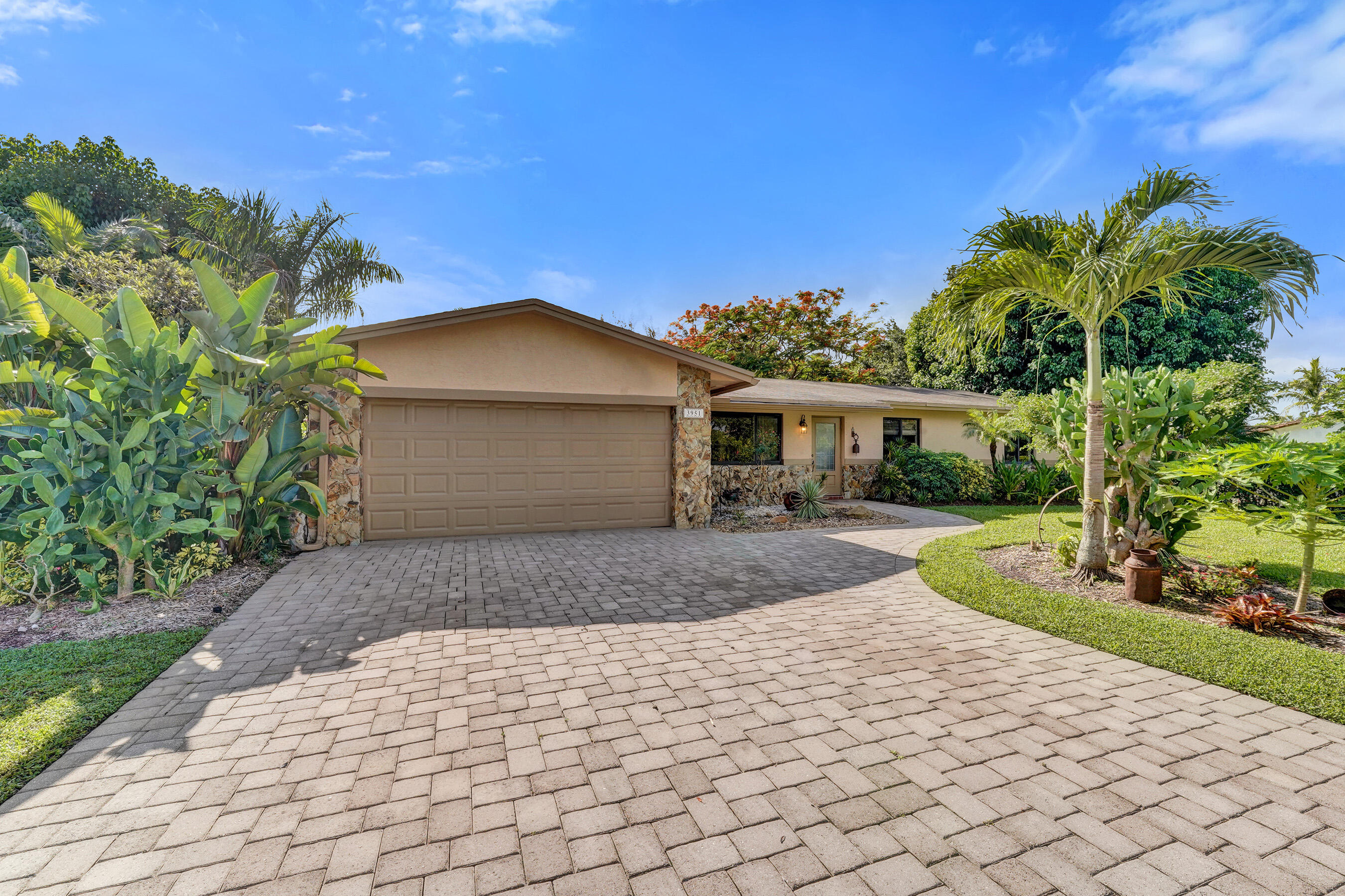 A hidden gem in a desirable equestrian community, this warm and welcoming ranch home is nestled among towering palms, tropical fruit trees and lush landscaping on more than an acre overlooking a wide canal. The setting offers a rare sense of privacy and tranquility while remaining close to Miami, Fort Lauderdale and all conveniences. The home welcomes you into a gracious living room highlighted by a striking limestone fireplace. It flows seamlessly into  the formal dining area, anchored by an updated kitchen featuring rich wood cabinetry, granite countertops, abundant storage, a spacious breakfast bar, an adjoining flex space and big family room provides additional living space that adds character and versatility to the heart of the home.  French Doors from dining area open to an expansive patio overlooking the tropical grounds and canal. The grounds are a tropical paradise with mature mango, avocado, banana and loquat trees, open green space and endless opportunities to enjoy the outdoors.  Hurricane-impact windows, accordion shutters and protective panels provide added peace of mind. Bring your horses, boat, RV and your vision.  With no HOA and room to roam, this special property offers the lifestyle that is increasingly difficult to find.  The acreage is stable-ready for equestrian enthusiasts, while the lush tropical setting creates a private retreat. Be sure to stop by the charming Little Free Library at the curb-- a welcoming touch that reflects the warmth and character of this unique home. Stop by and take a look!